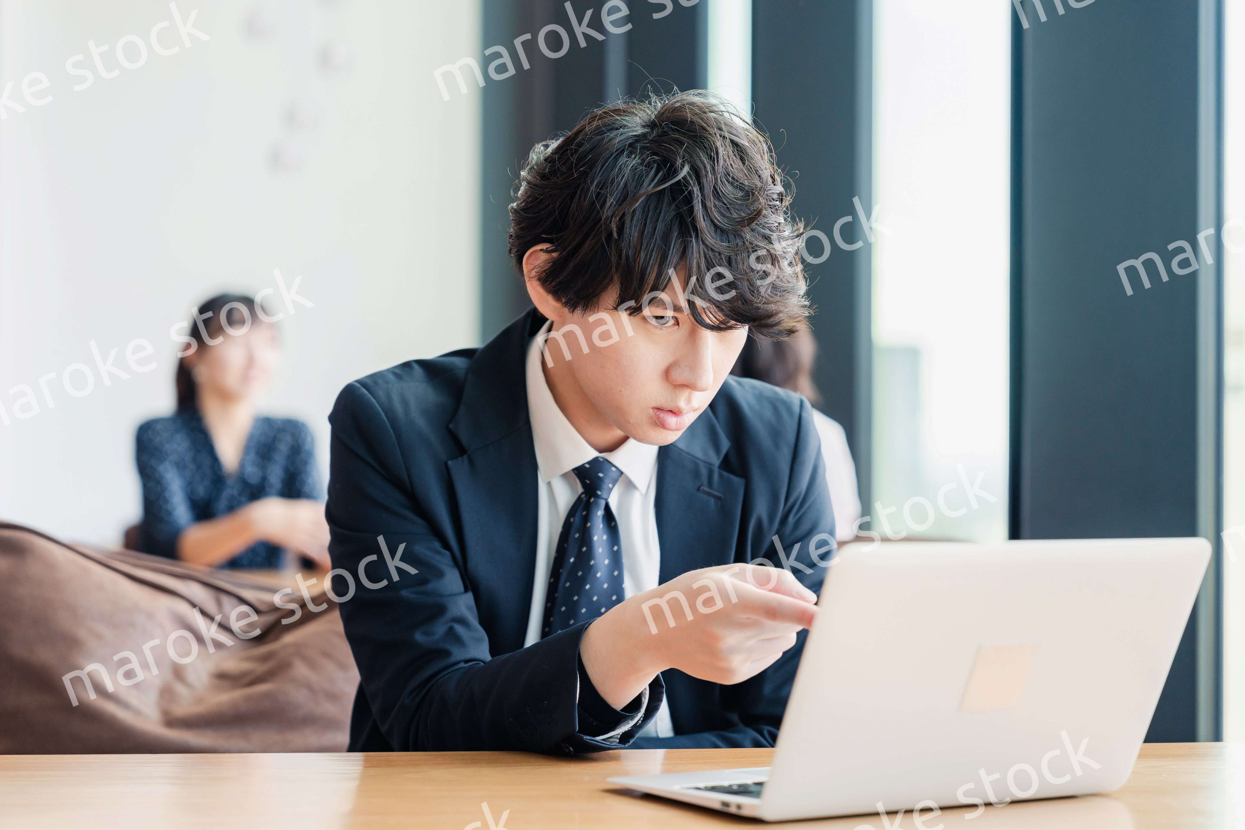 オフィスでパソコンと格闘するビジネスマン