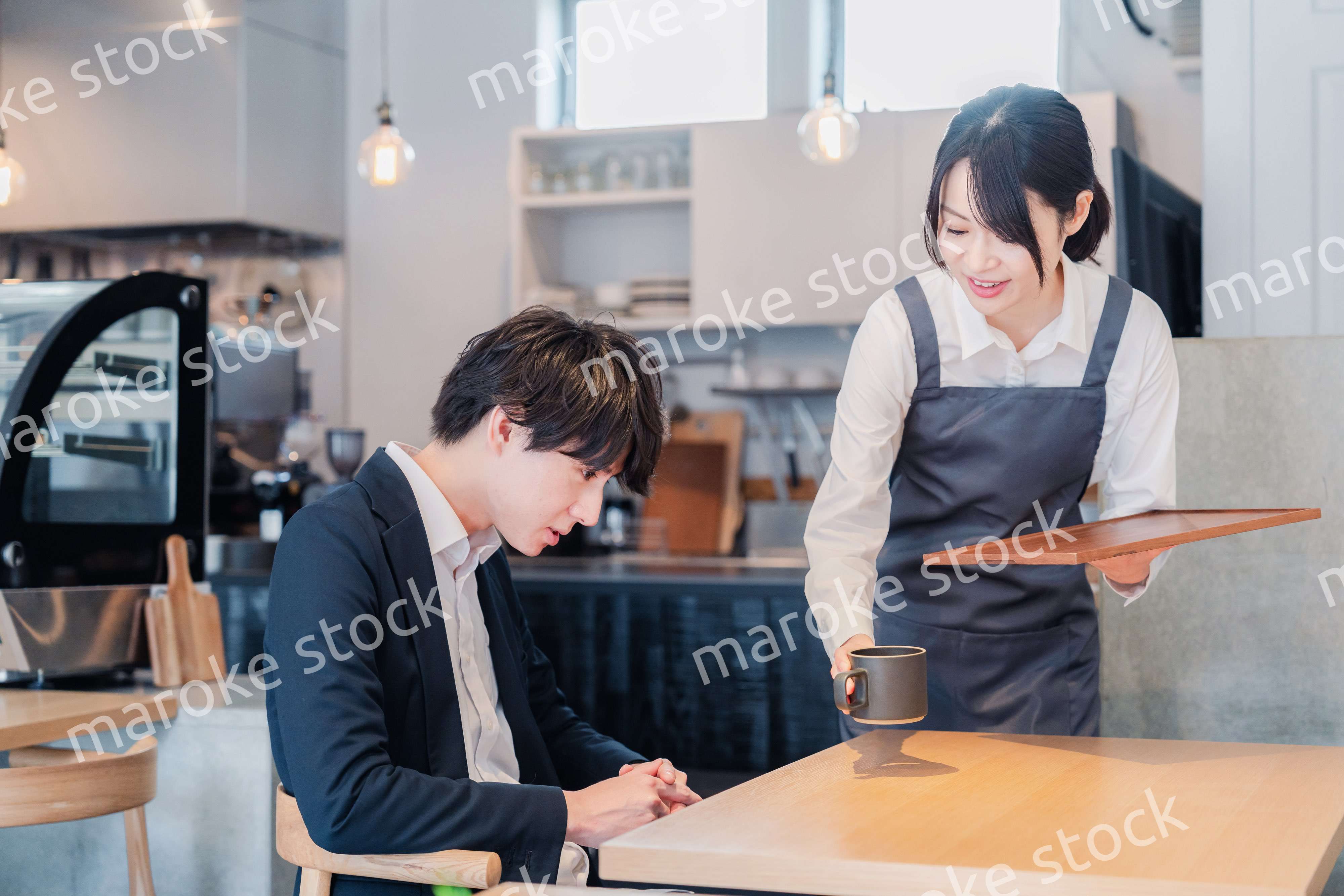 カフェで男性客と話すスタッフ