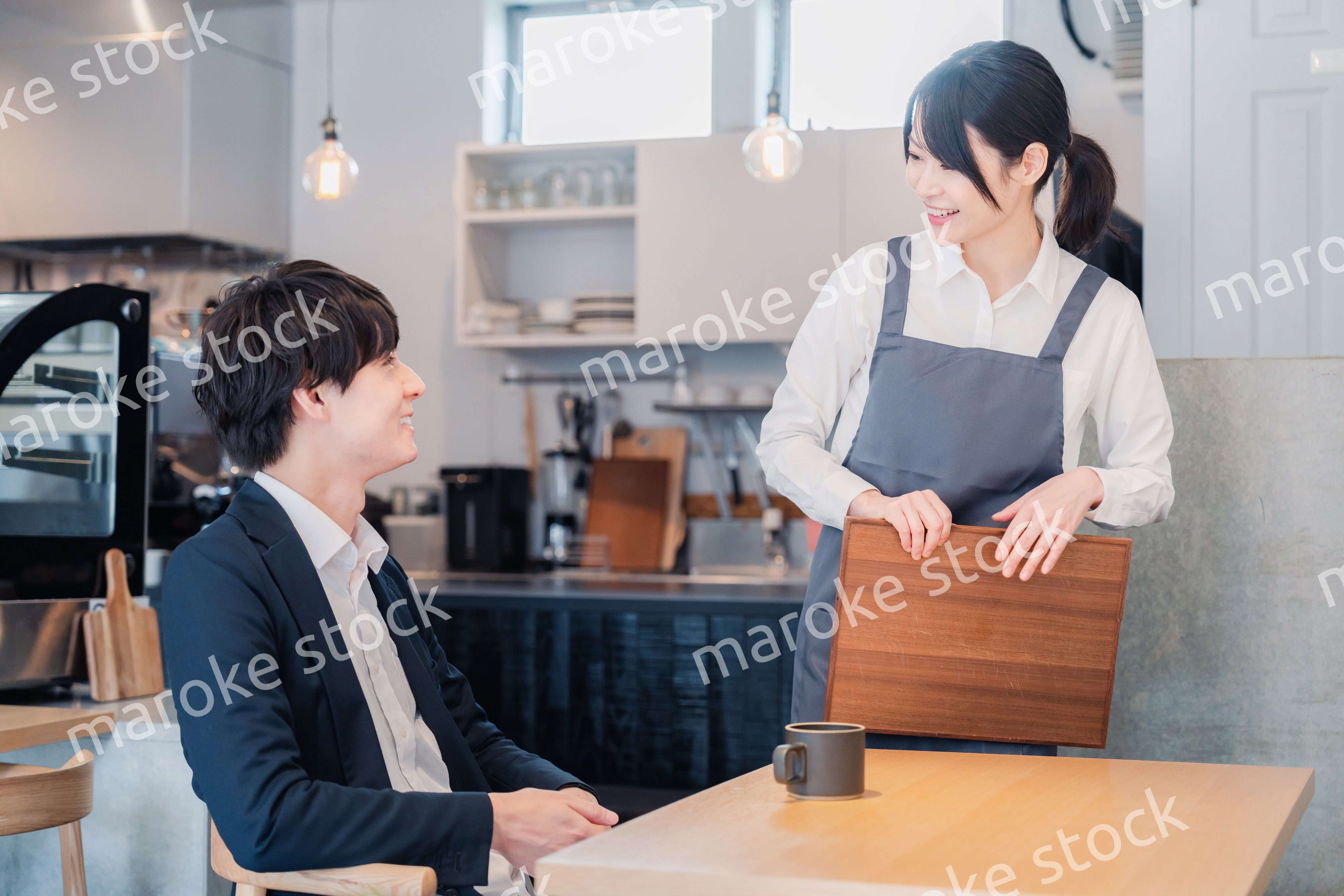 カフェで男性客と話すスタッフ