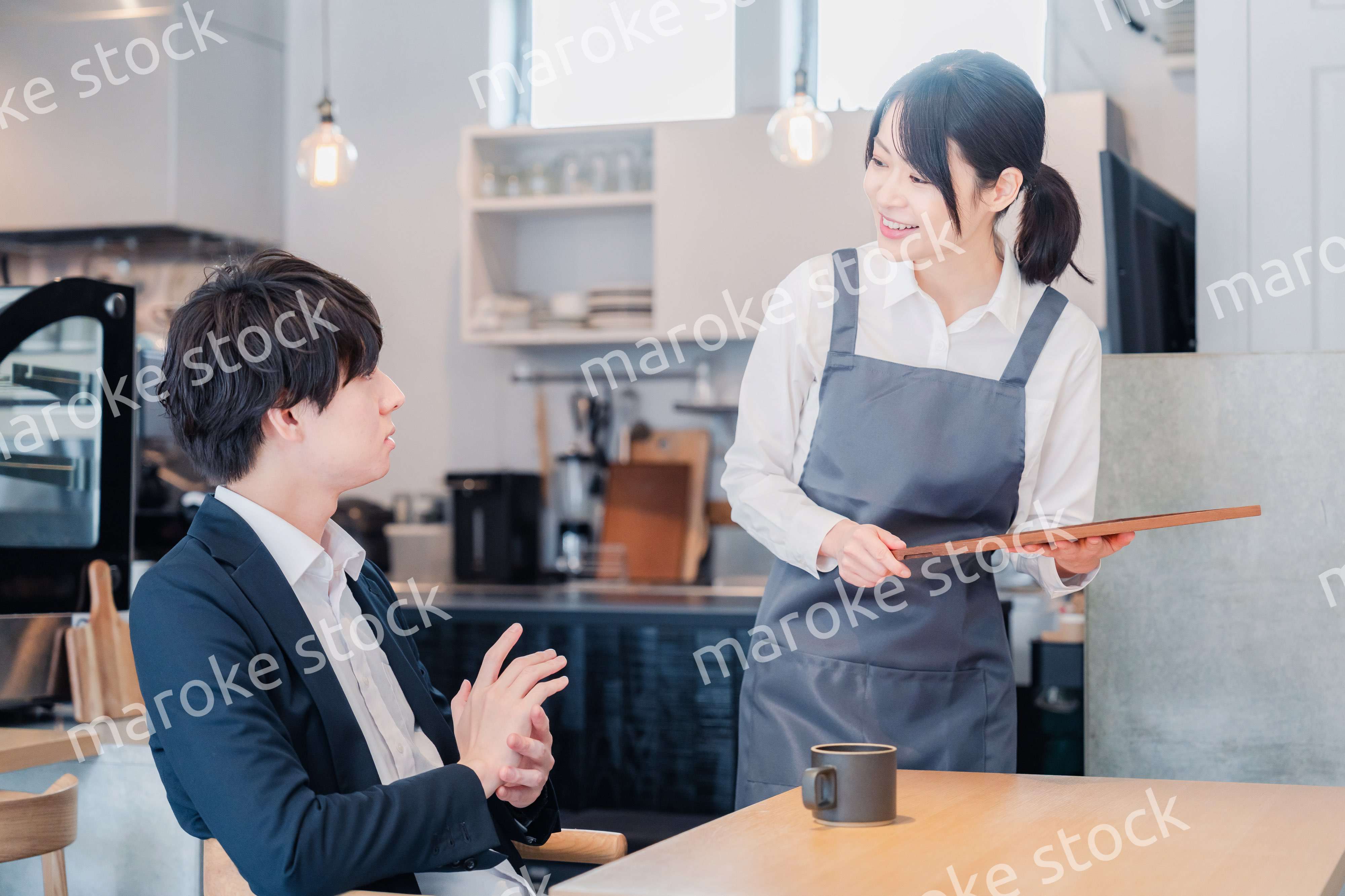 カフェで男性客と話すスタッフ