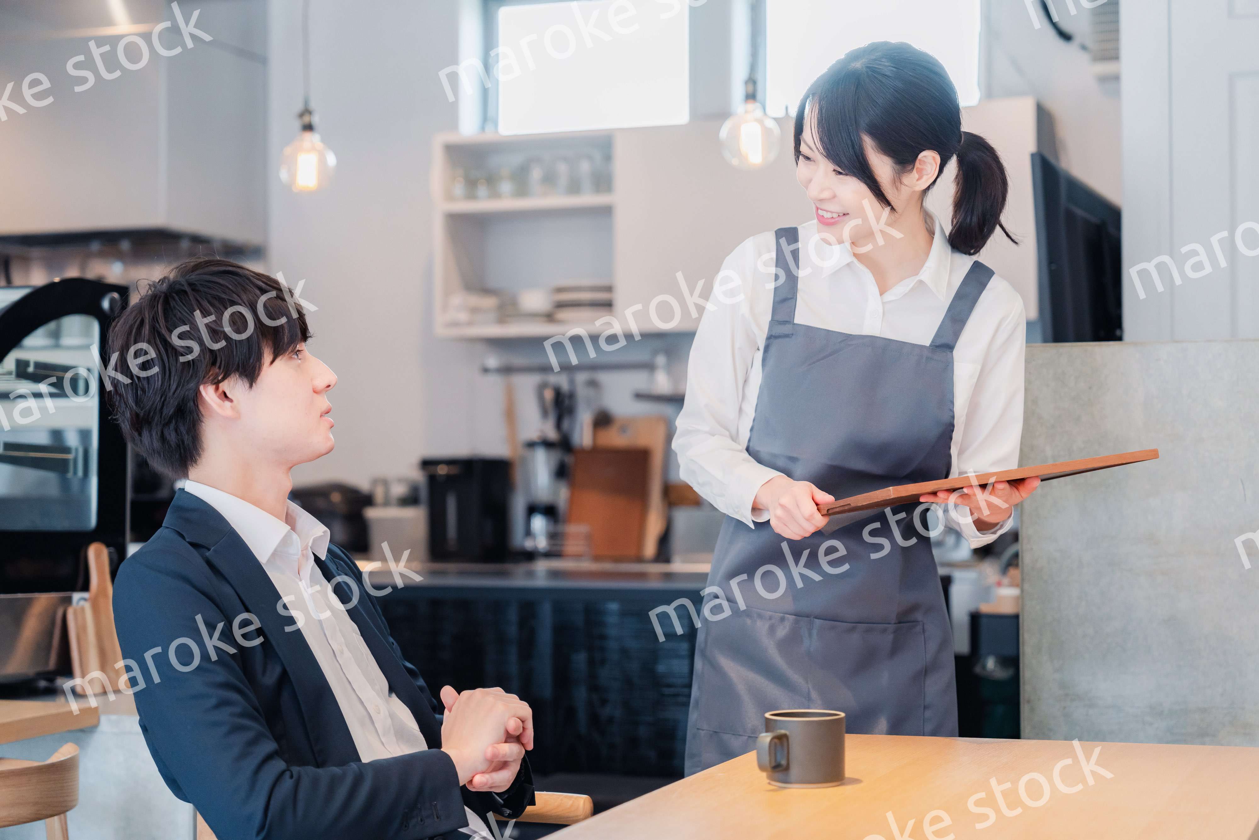 カフェで男性客と話すスタッフ