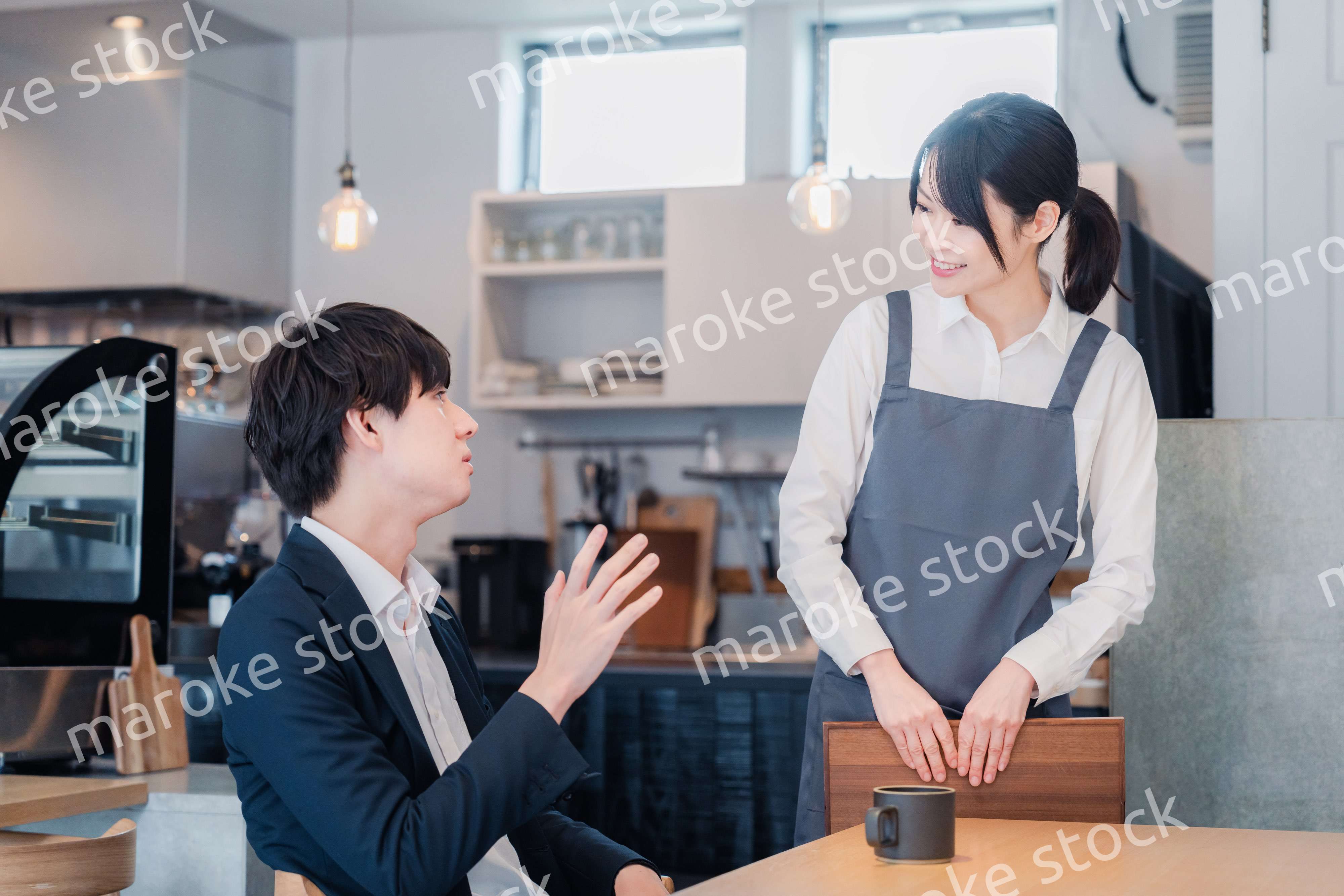 カフェで男性客と話すスタッフ