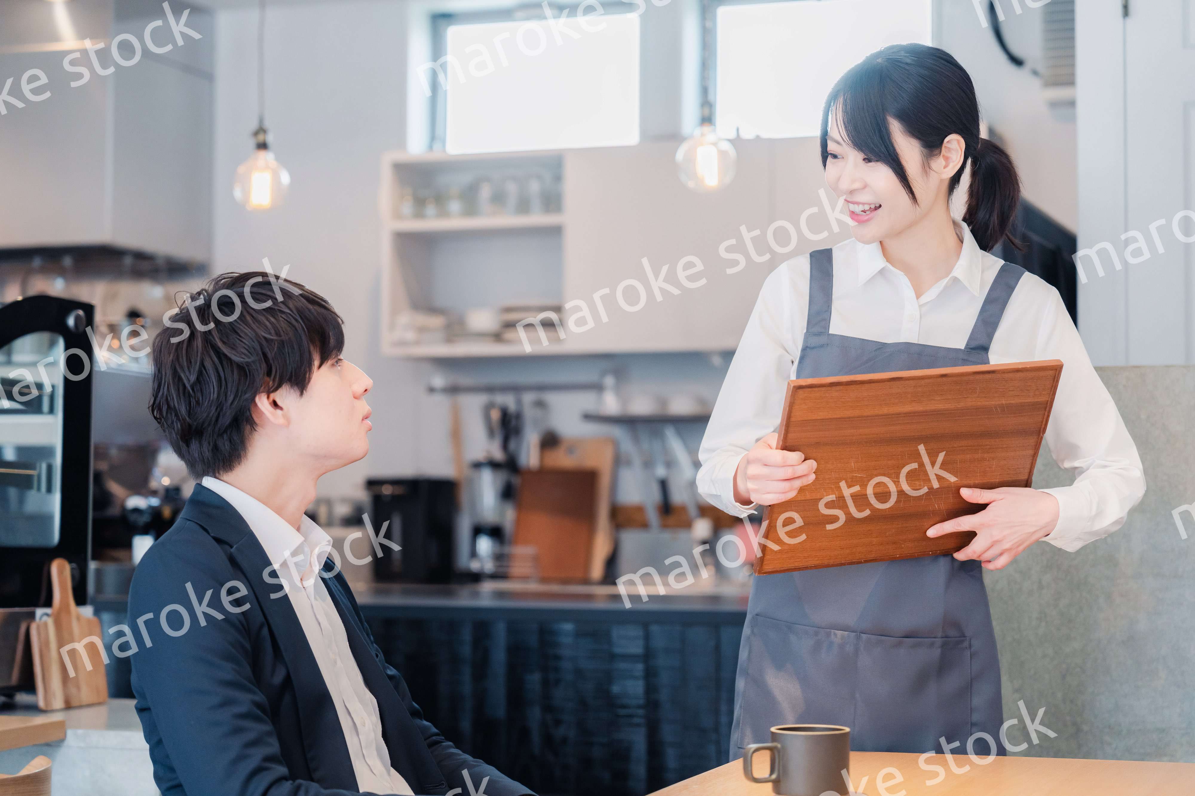 カフェで男性客と話すスタッフ