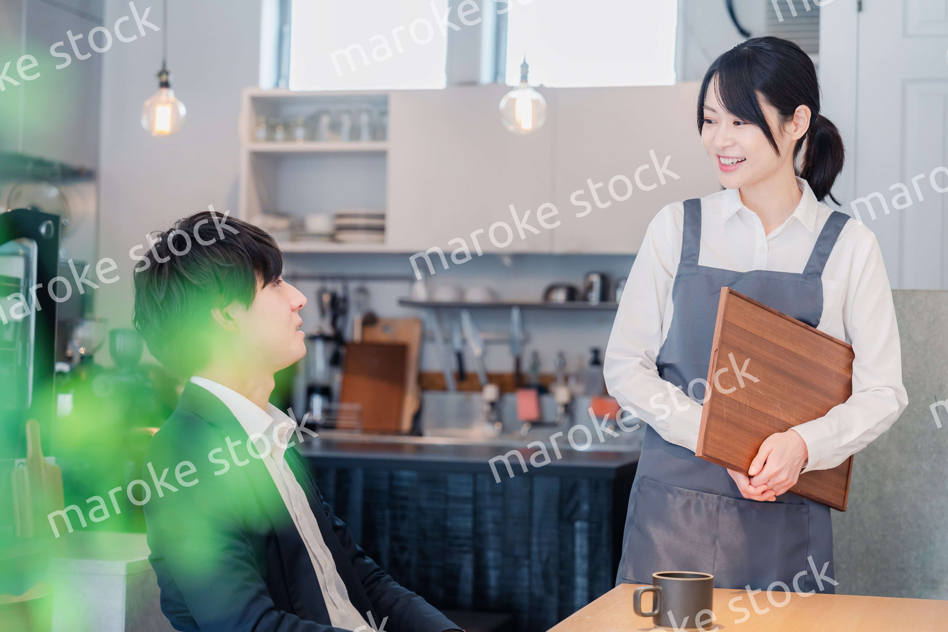 カフェで男性客と話すスタッフ