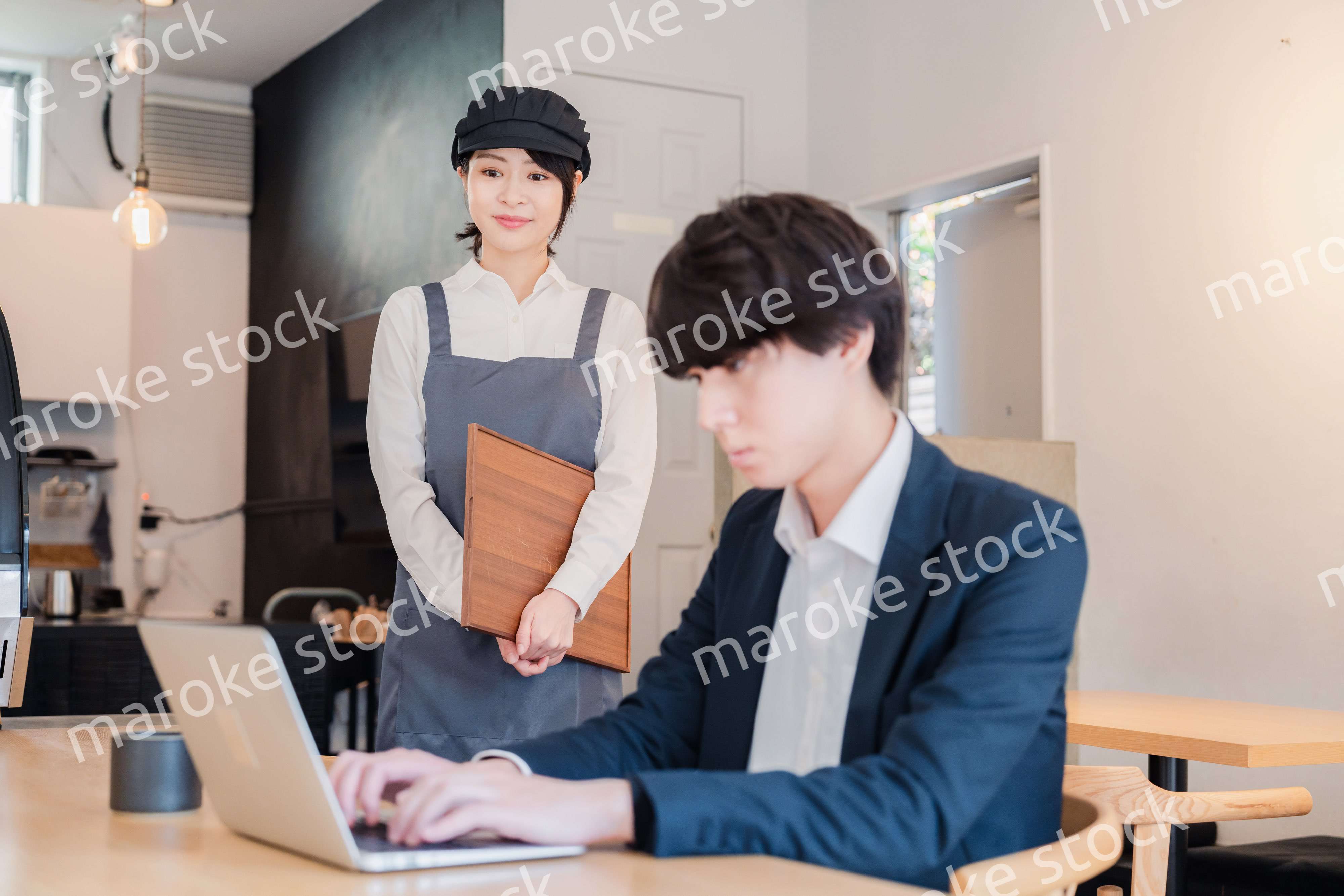 カフェで男性客と話すスタッフ