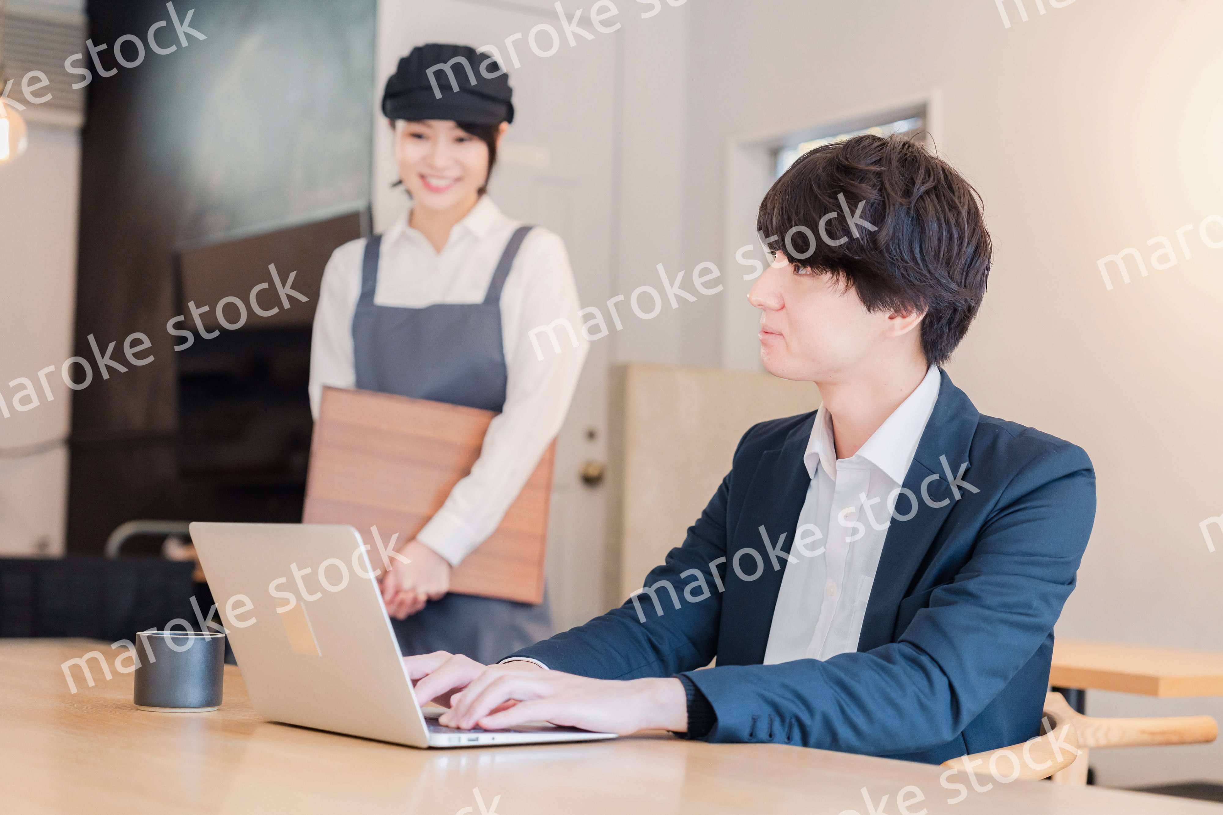 カフェで男性客と話すスタッフ