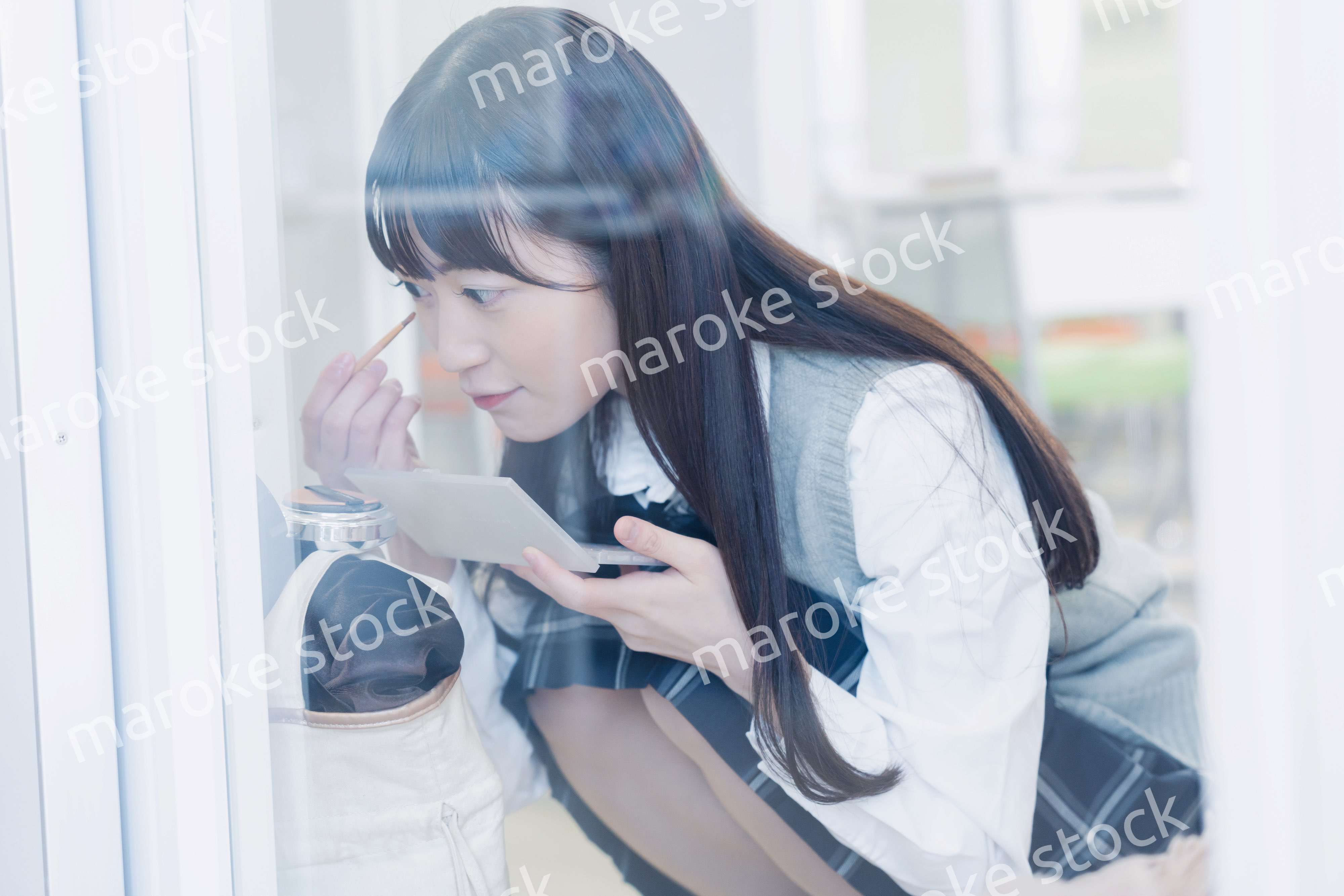 学校でメイクをする女子高生