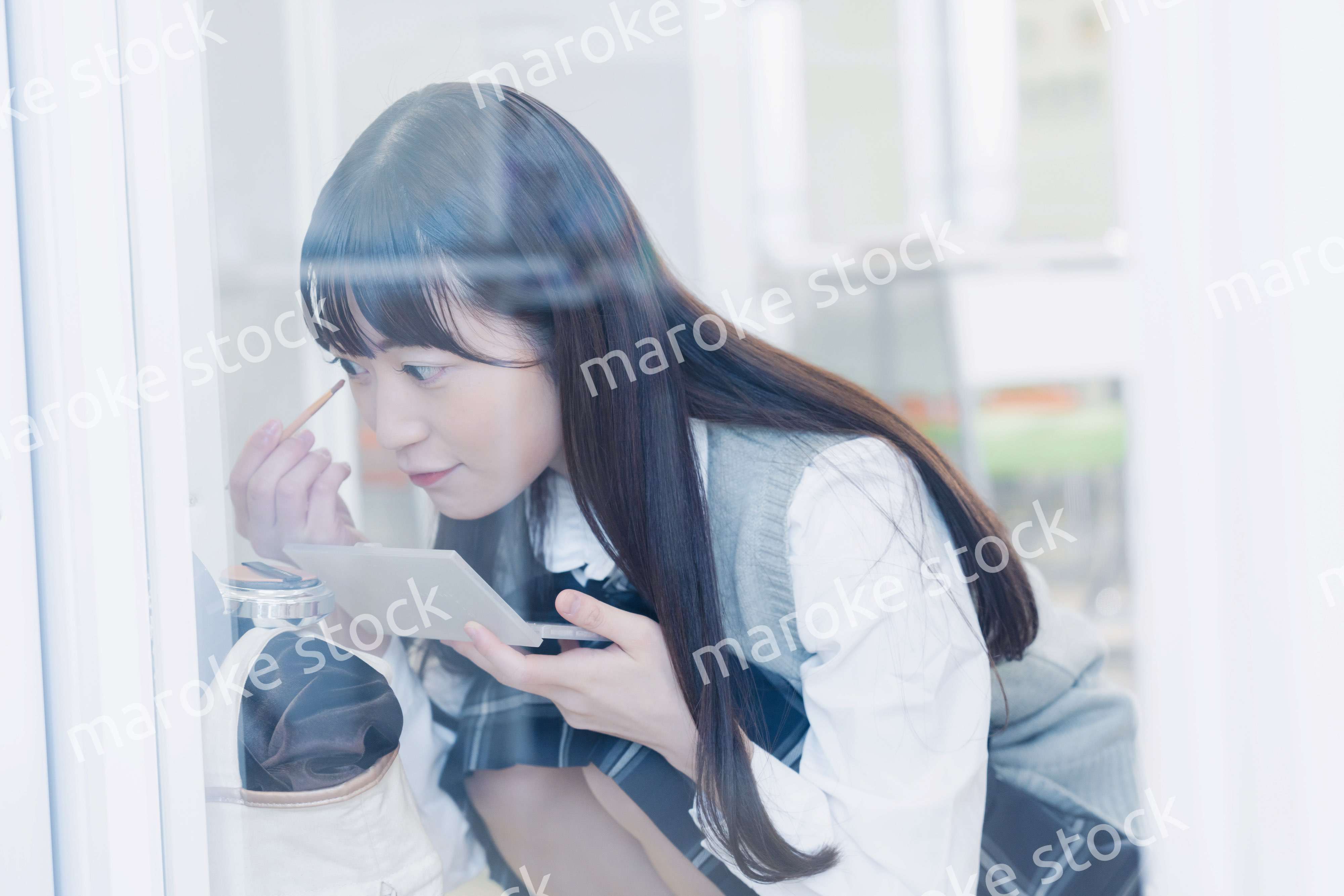 学校でメイクをする女子高生