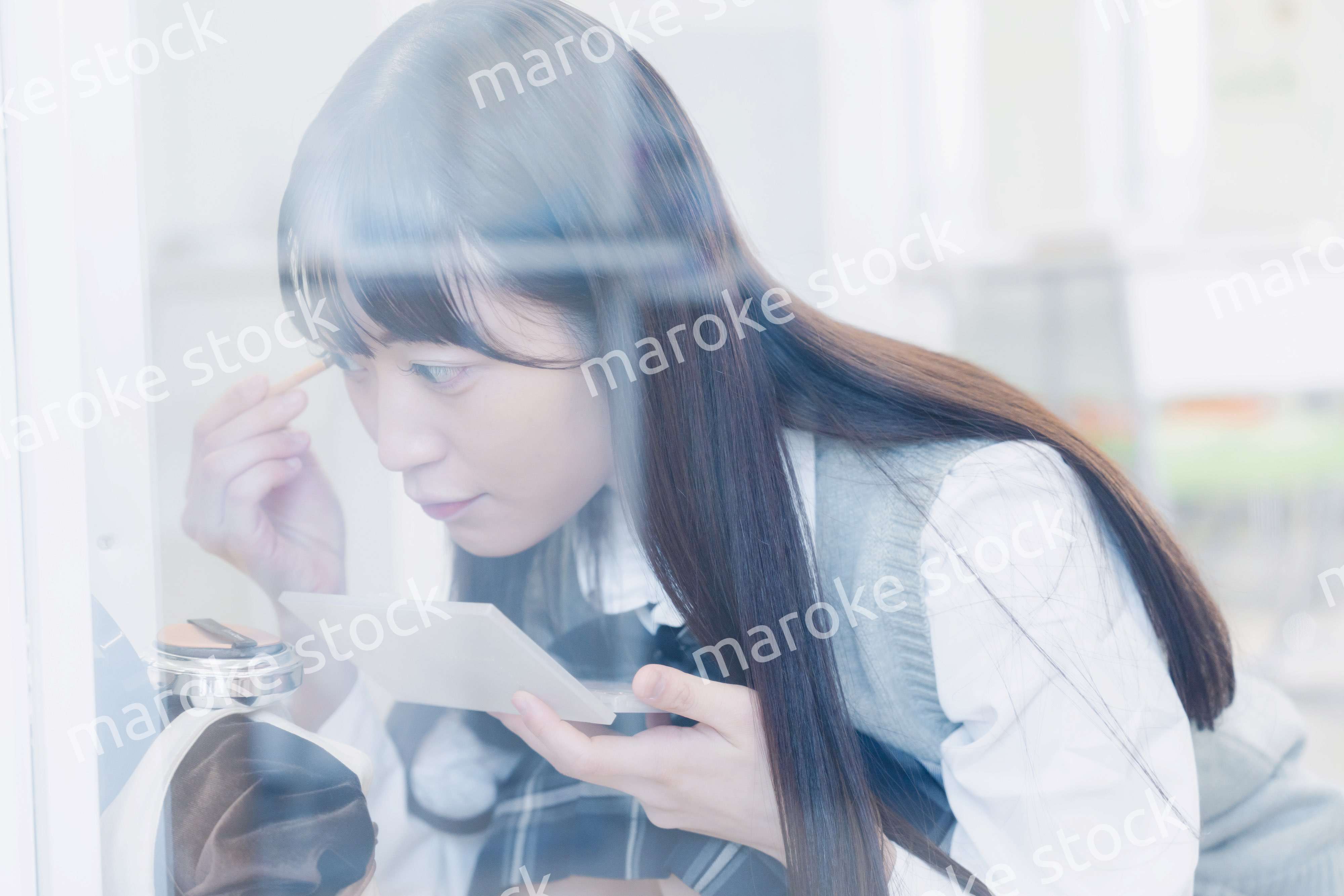 学校でメイクをする女子高生