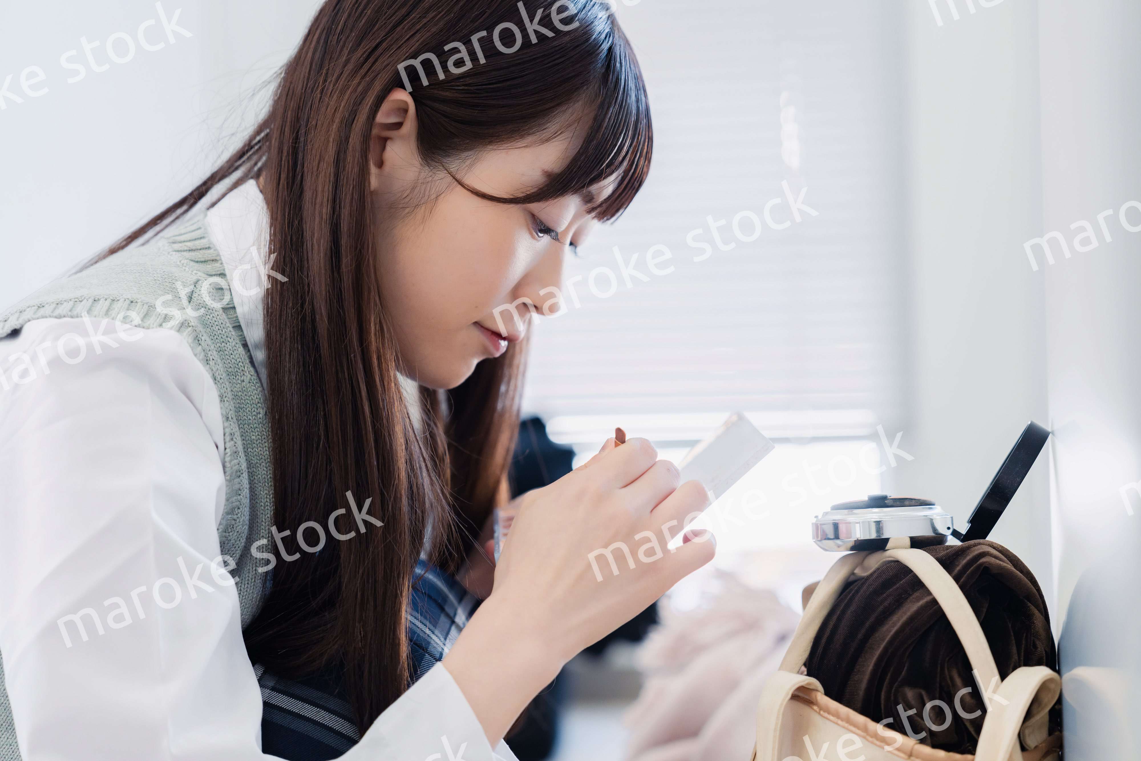 学校でメイクをする女子高生