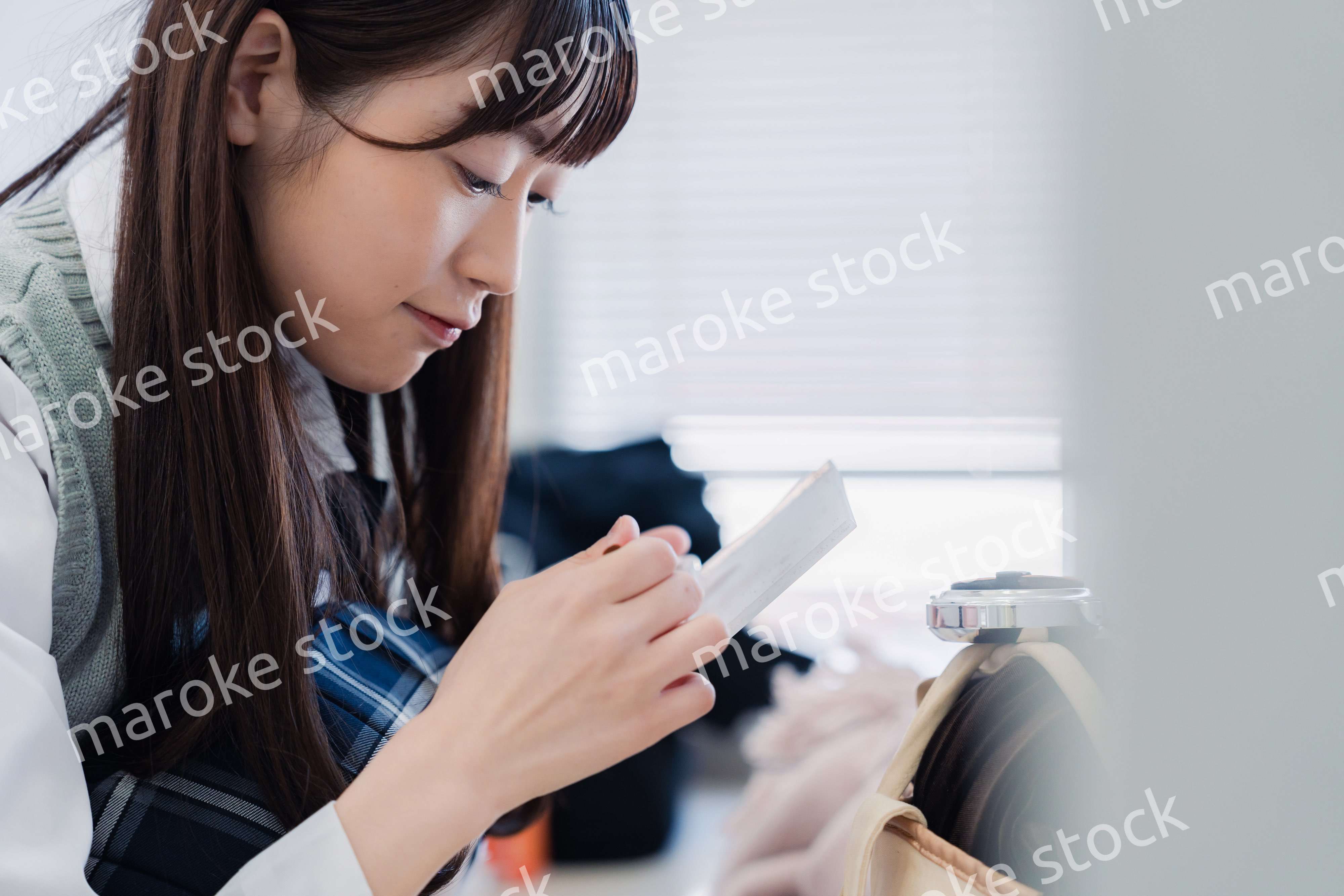 学校でメイクをする女子高生