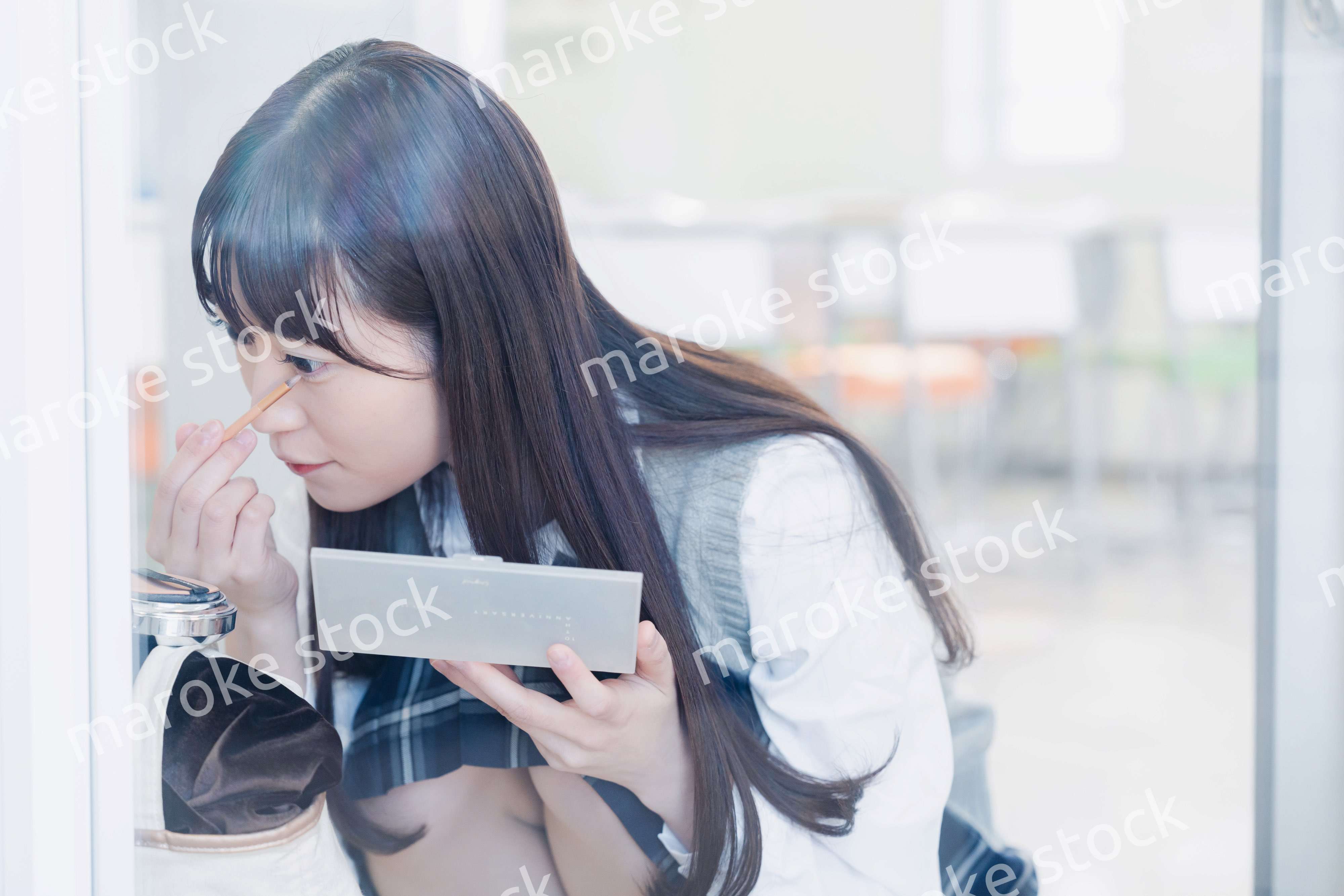 学校でメイクをする女子高生