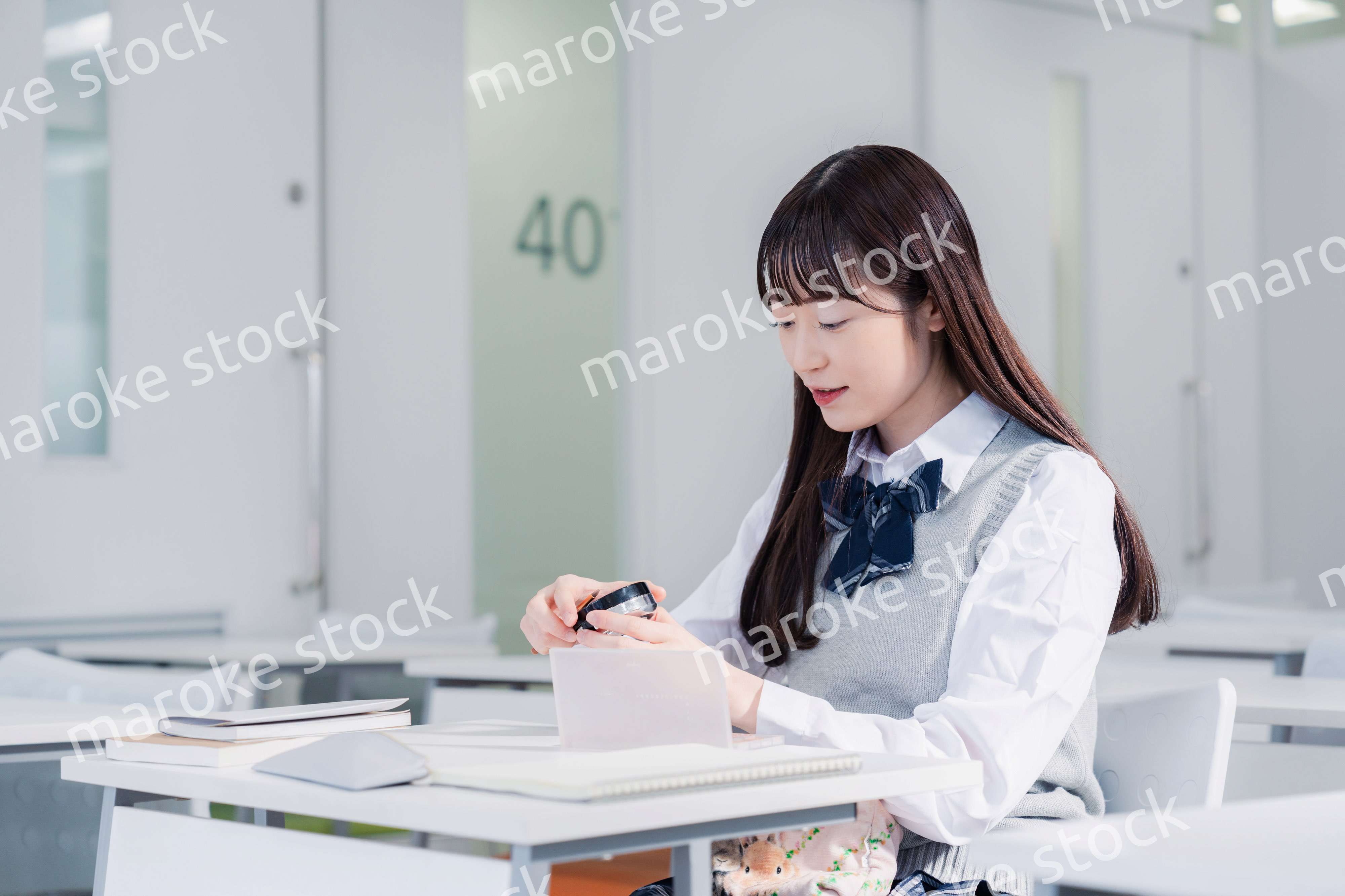 学校でメイクをする女子高生