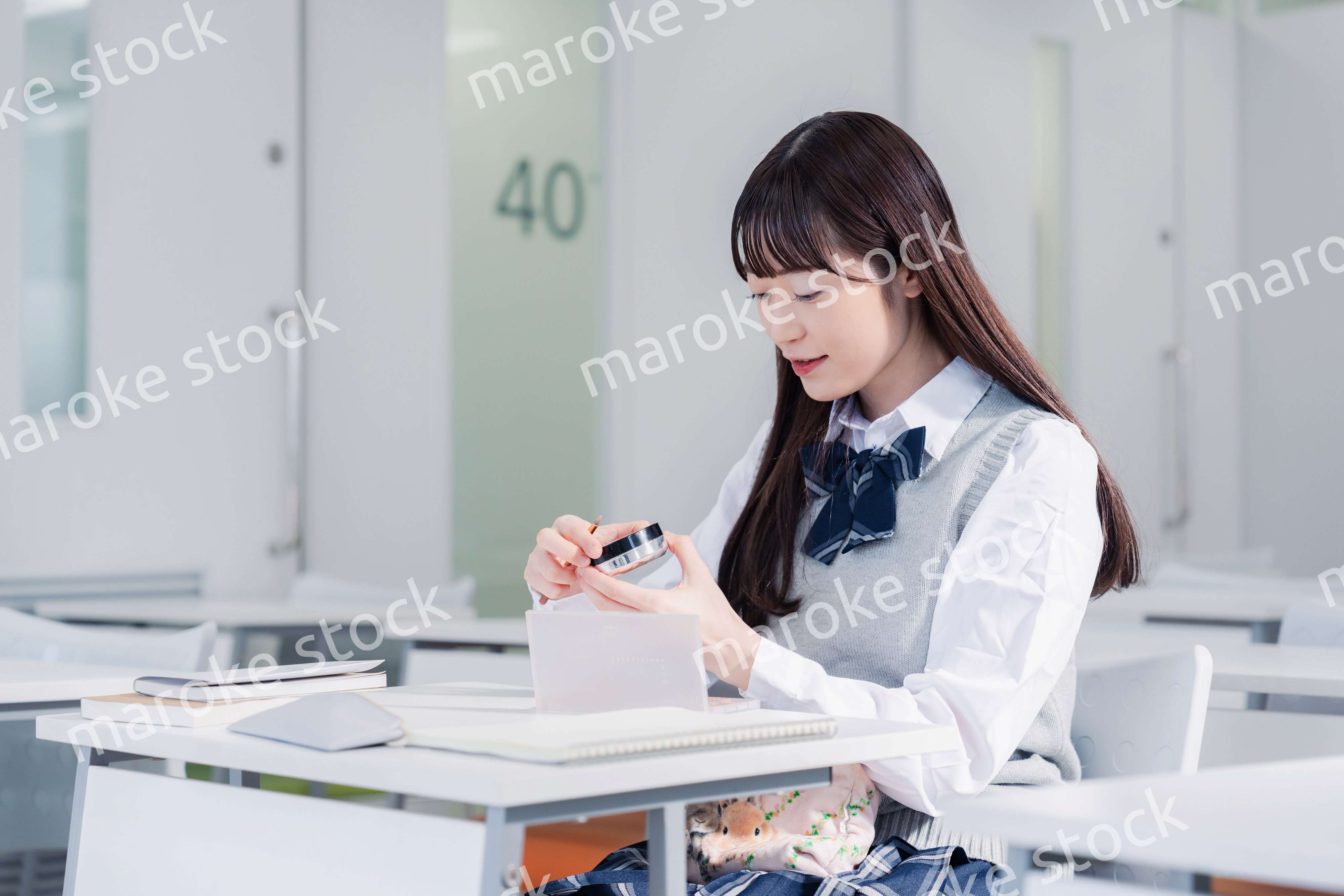 学校でメイクをする女子高生