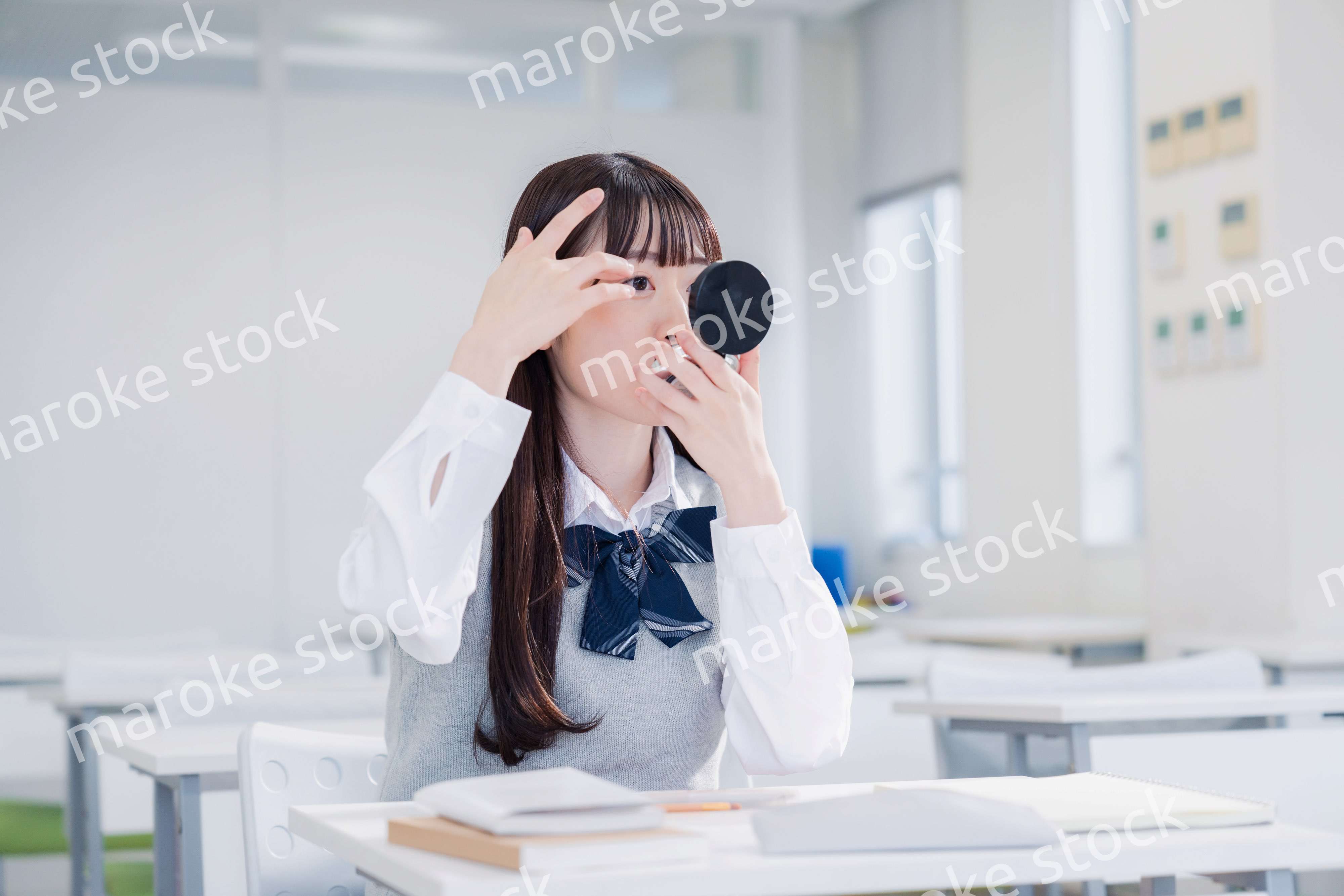 学校でメイクをする女子高生