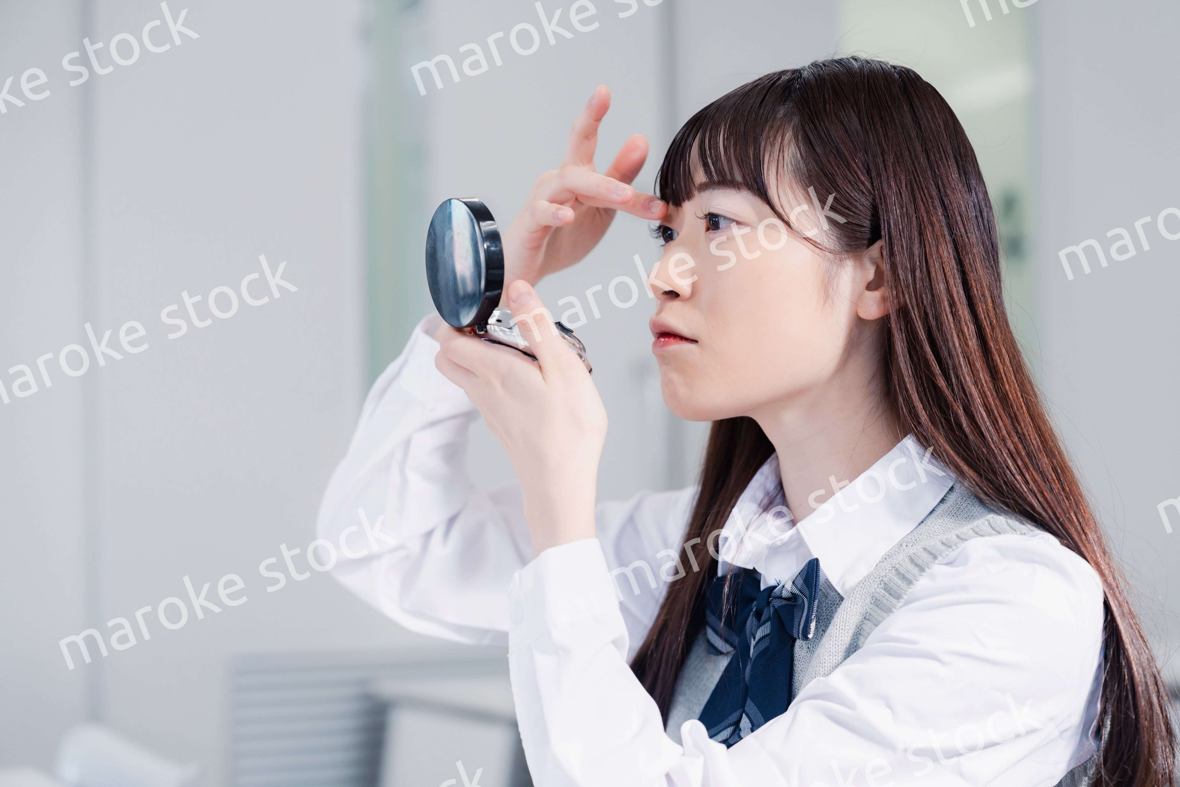 学校でメイクをする女子高生