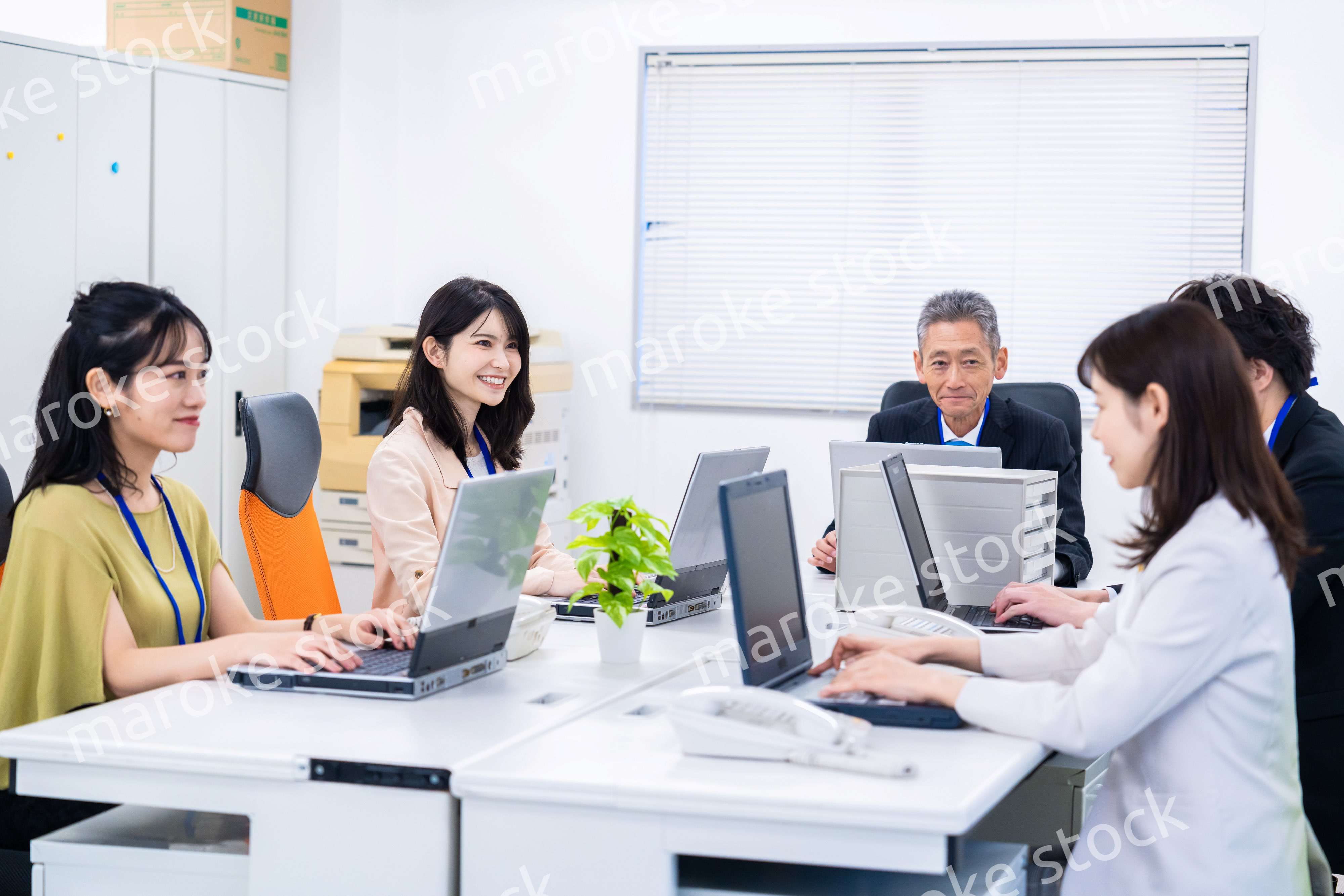 楽しくオフィスで仕事をするスタッフ