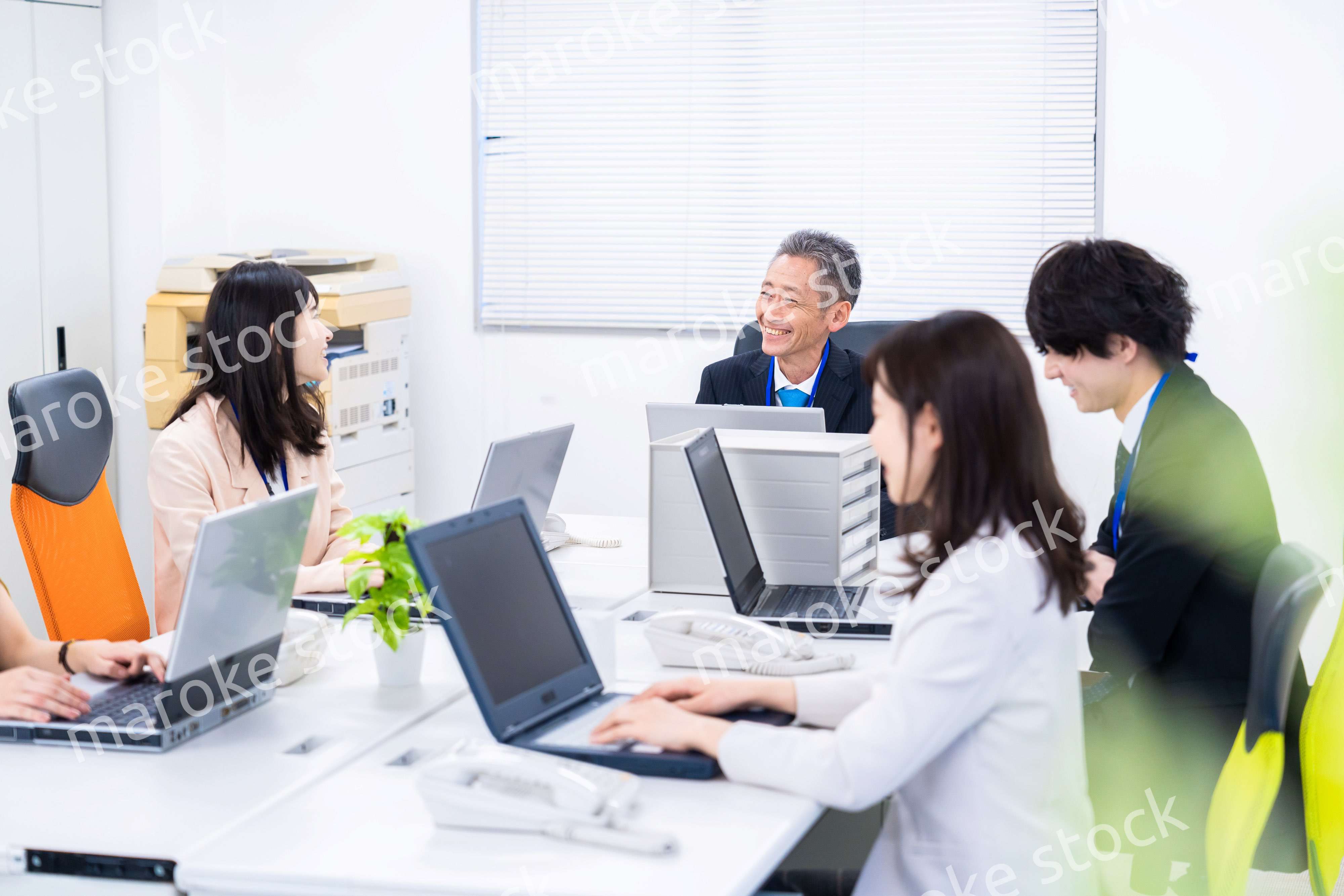 楽しくオフィスで仕事をするスタッフ