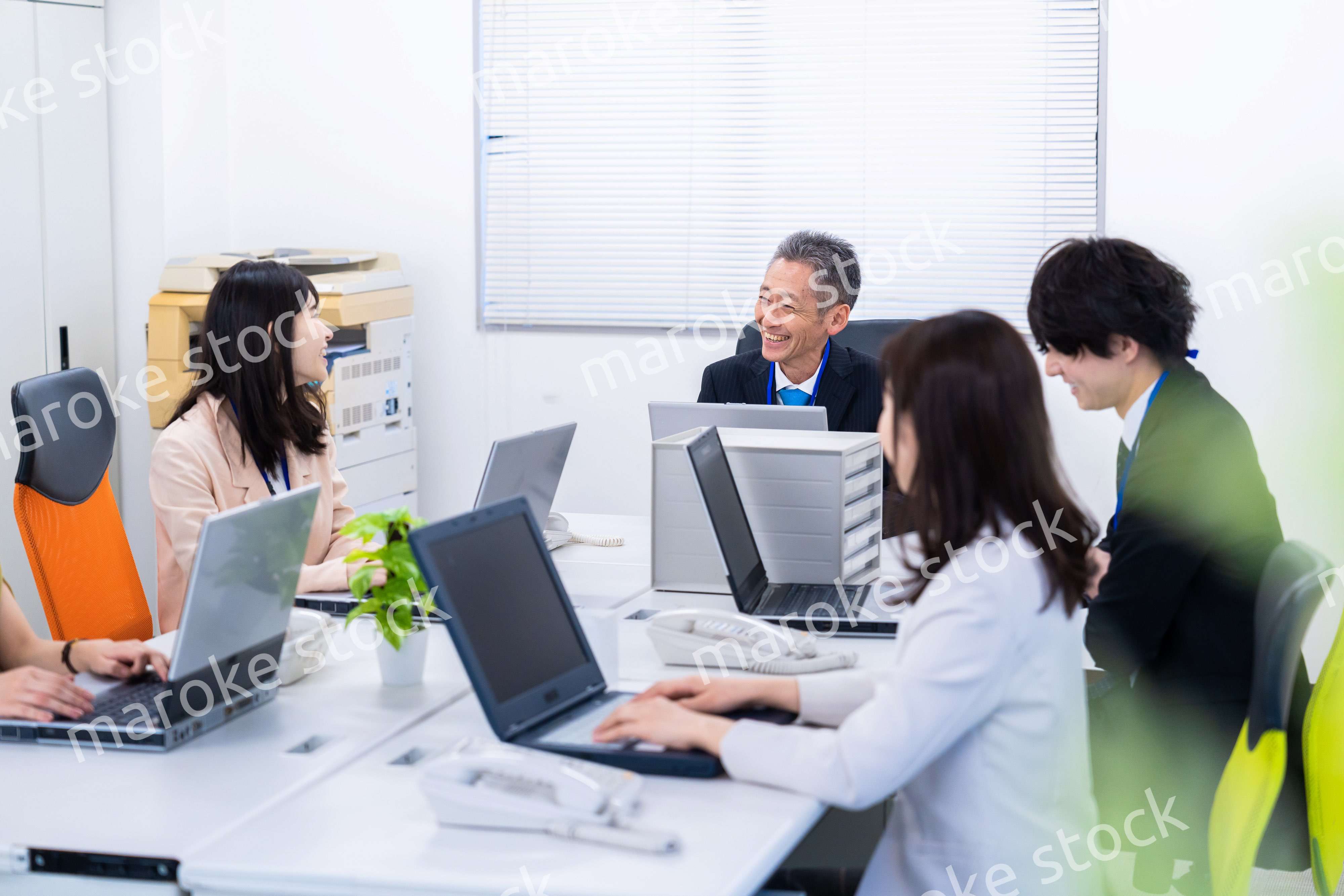 楽しくオフィスで仕事をするスタッフ