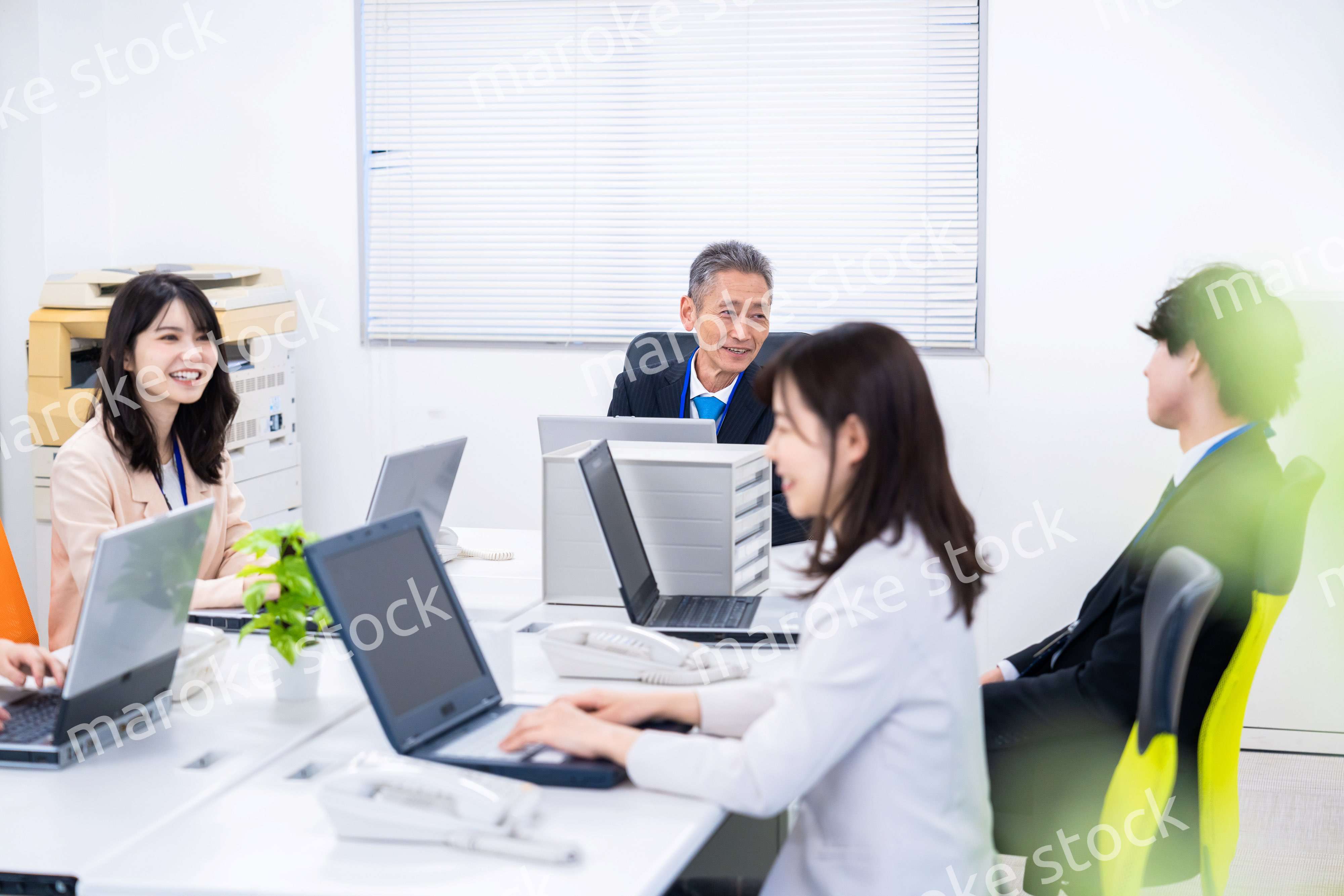 楽しくオフィスで仕事をするスタッフ