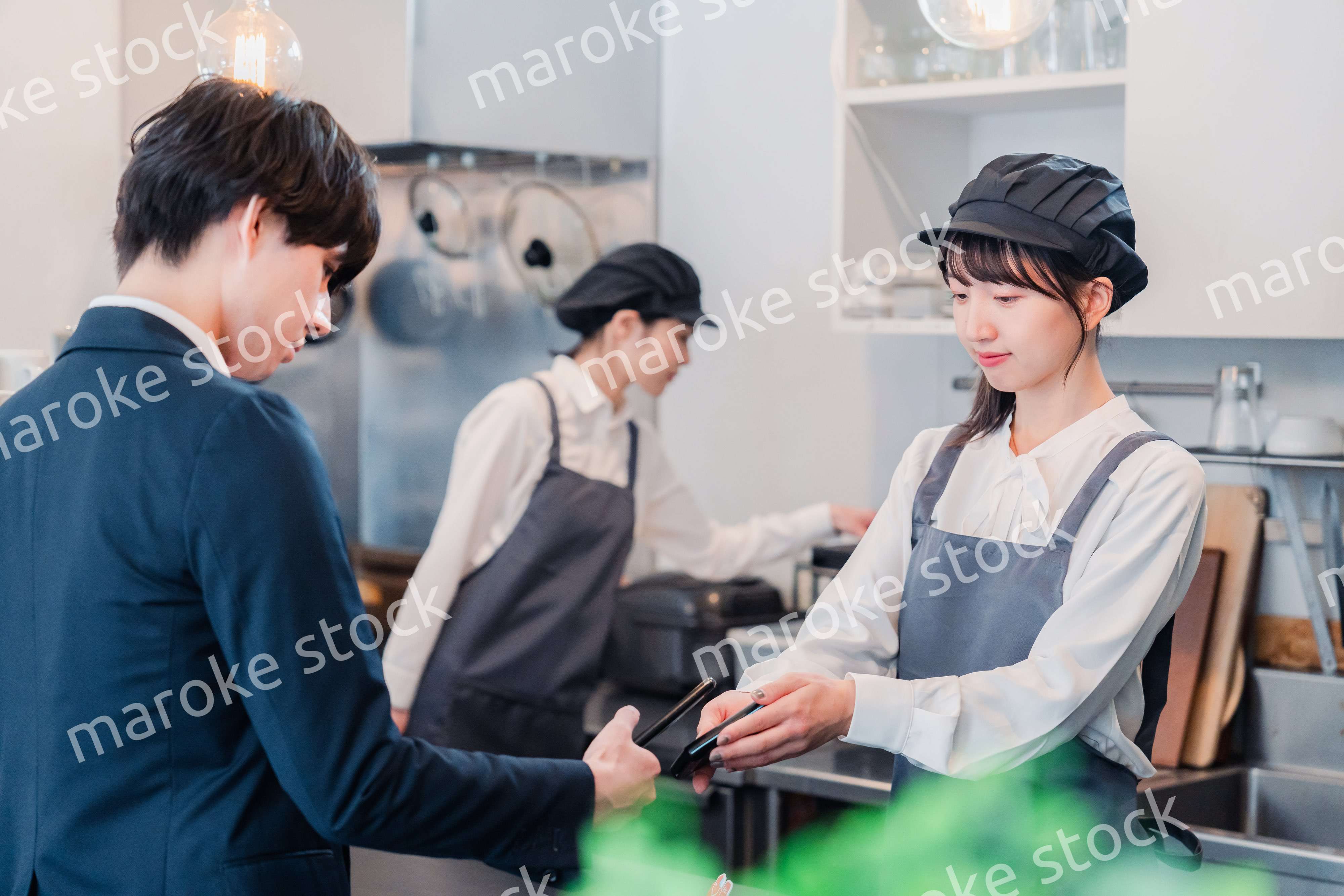 スマホでタッチ決済をする男性