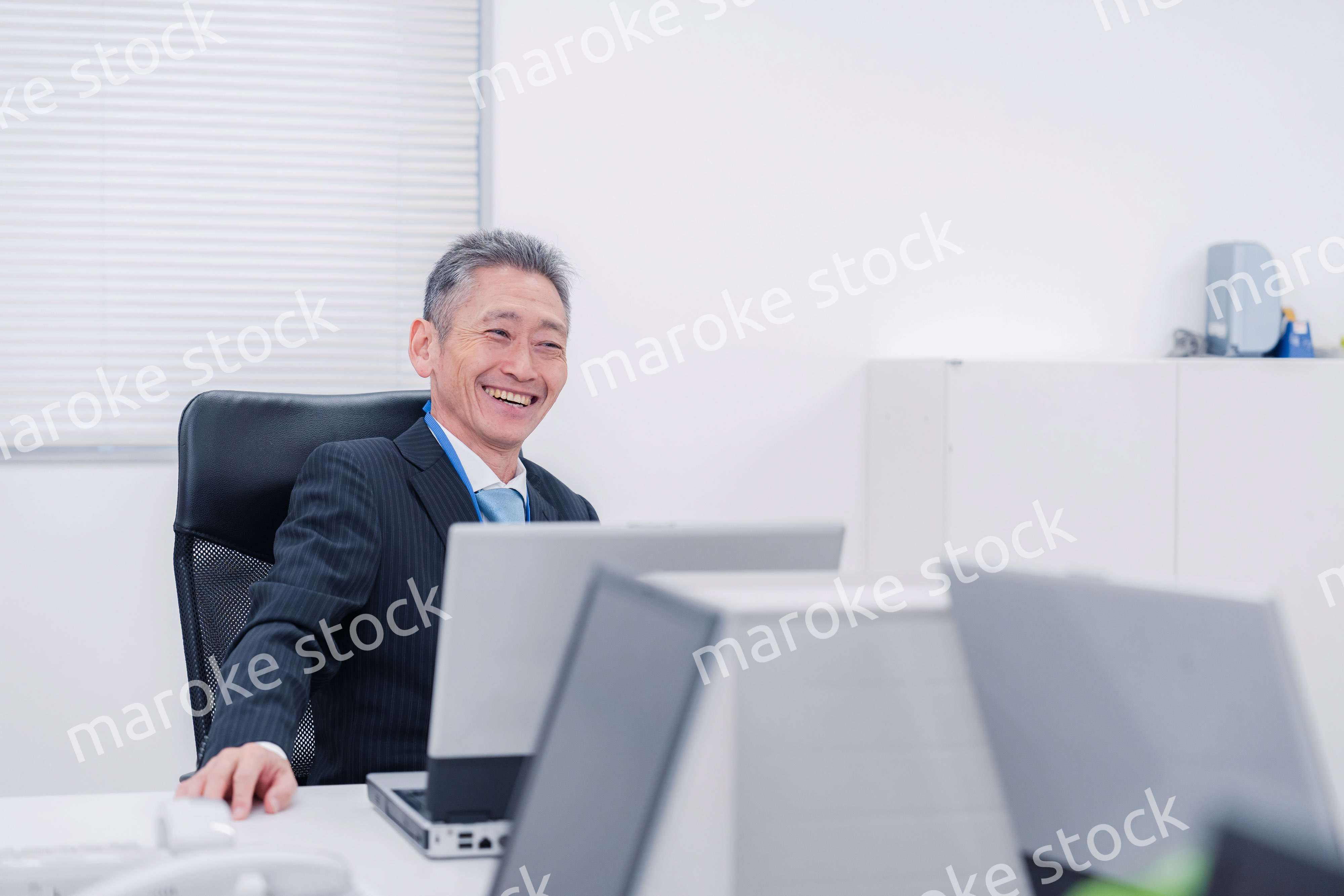 会社で自分の意見を語る管理職の男性