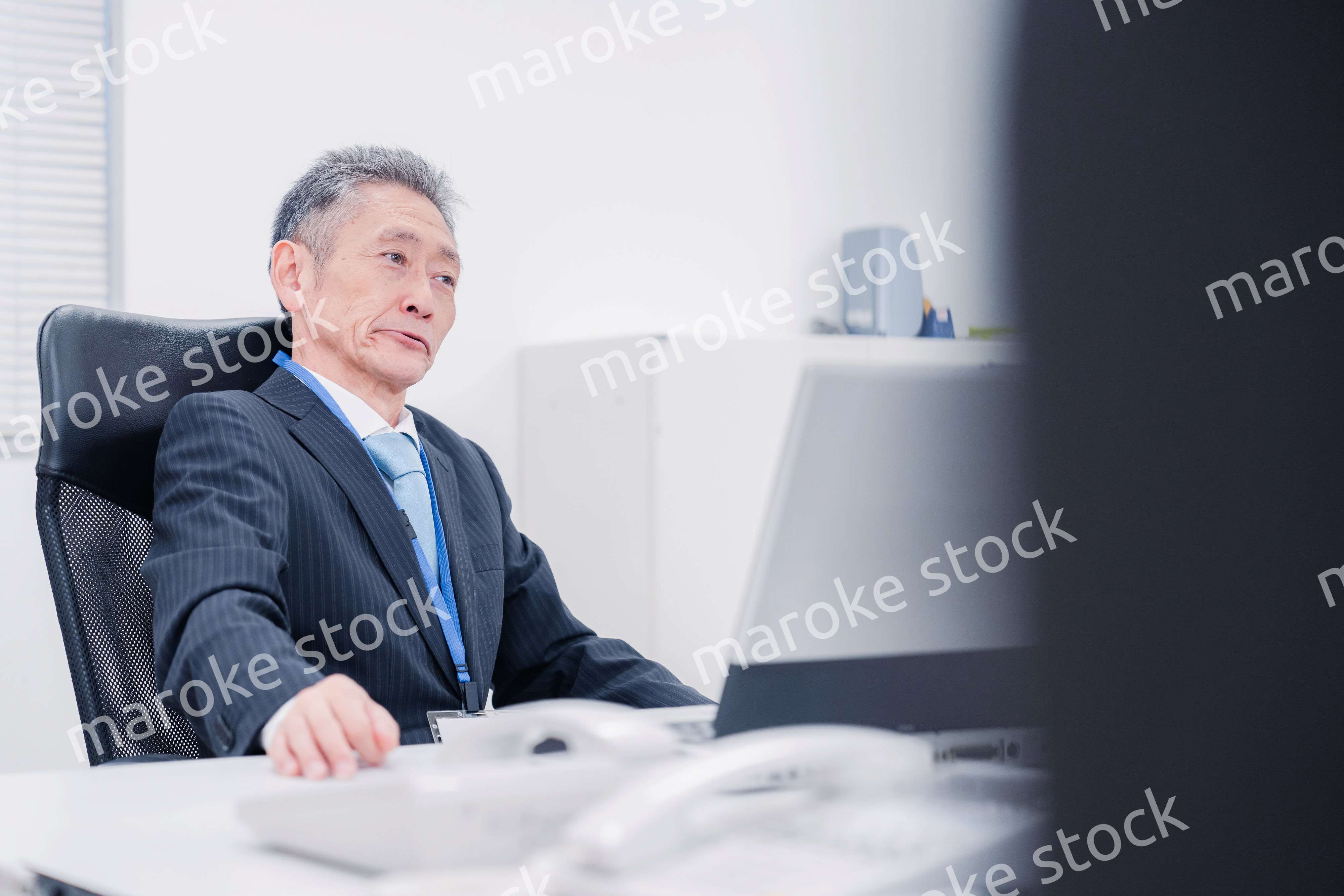 会社で自分の意見を語る管理職の男性