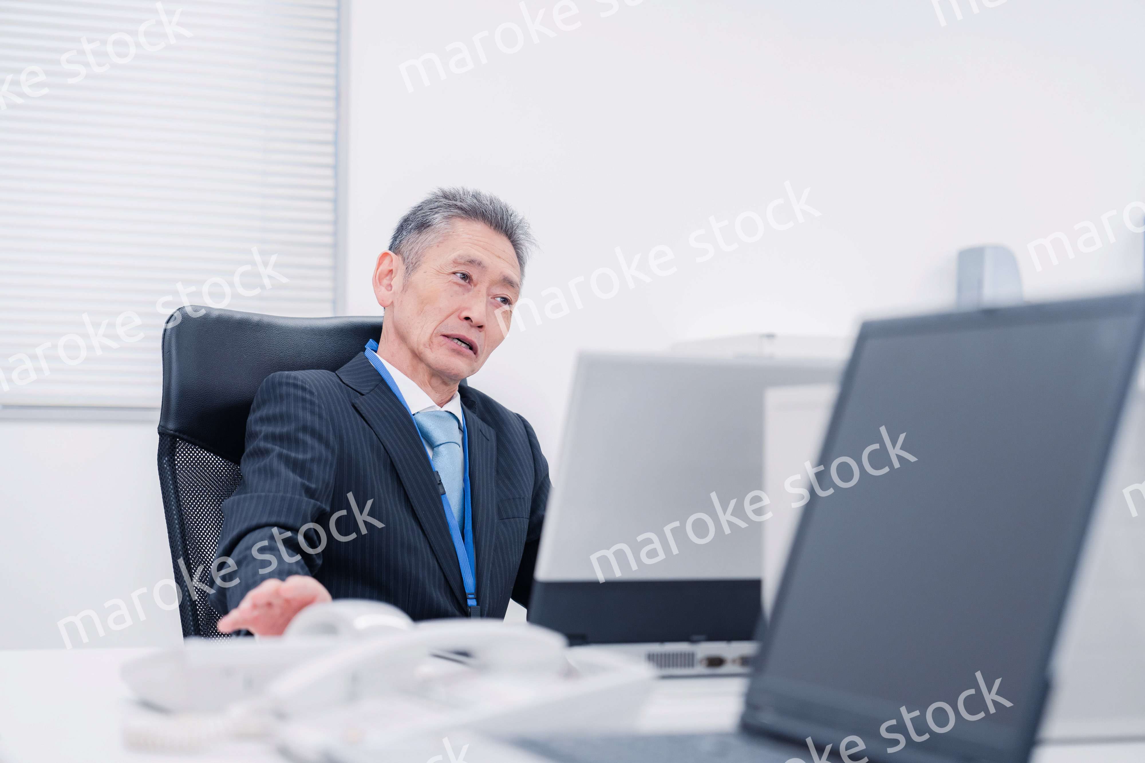 会社で自分の意見を語る管理職の男性