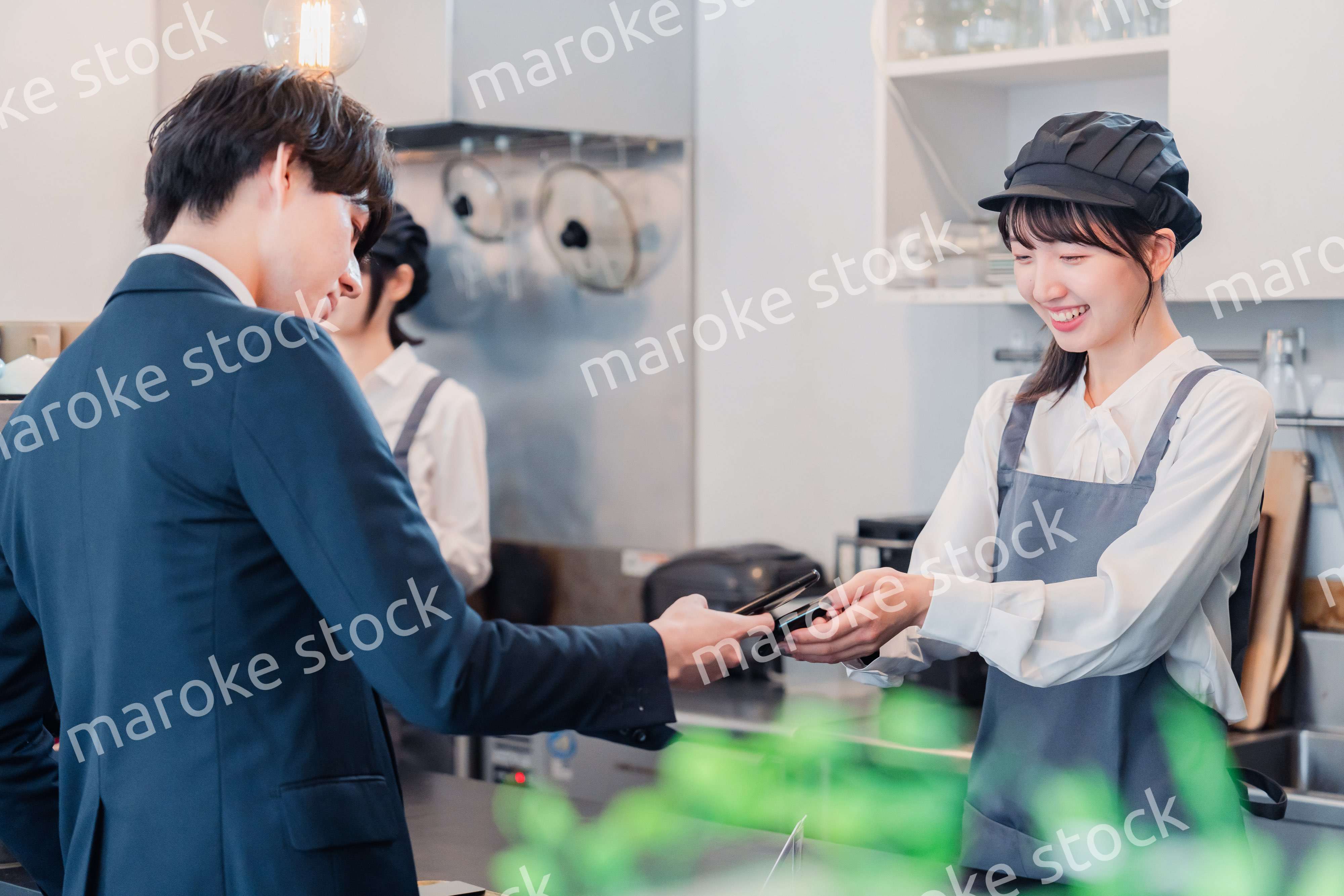 スマホでタッチ決済をする男性