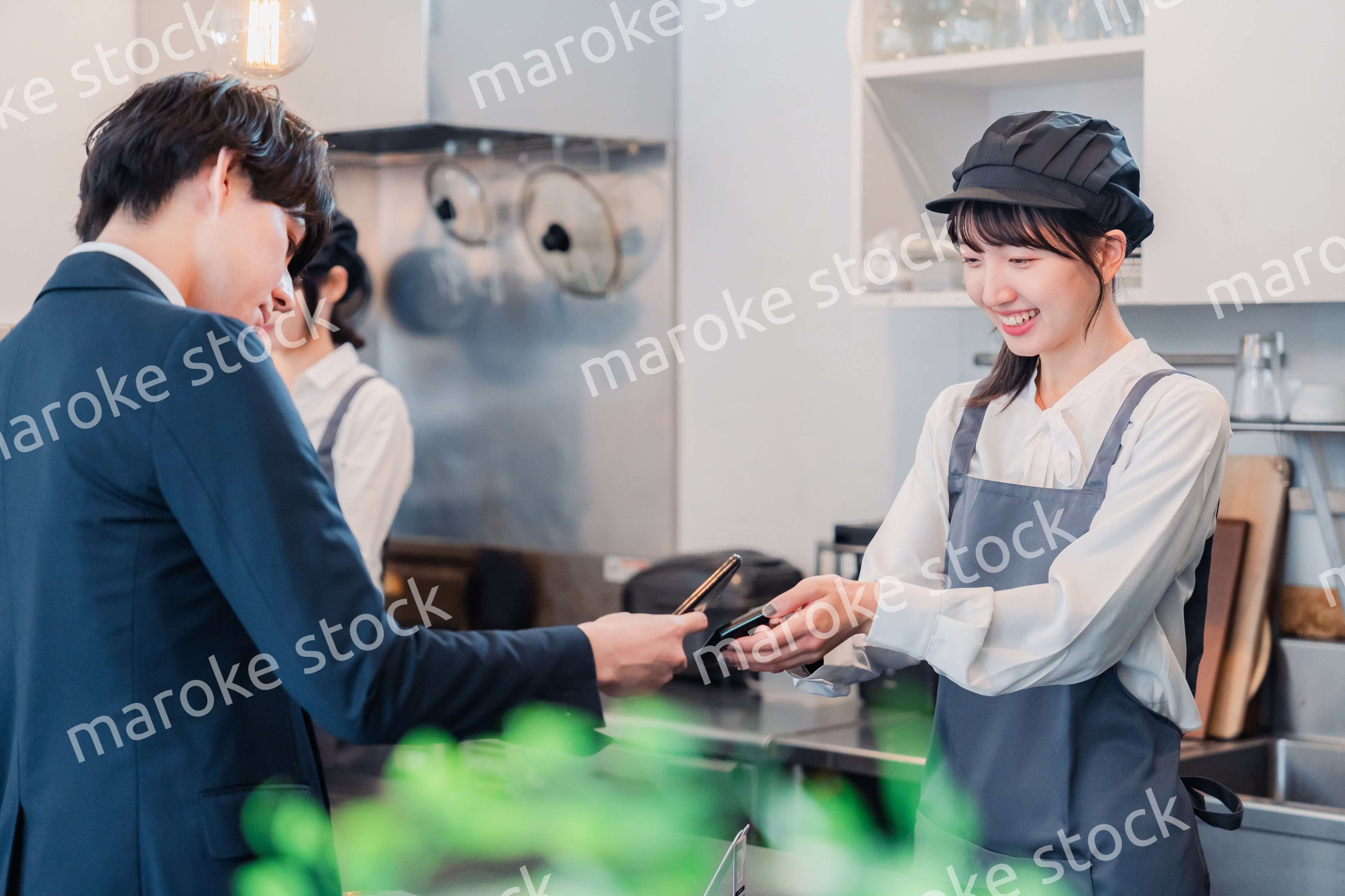 スマホでタッチ決済をする男性