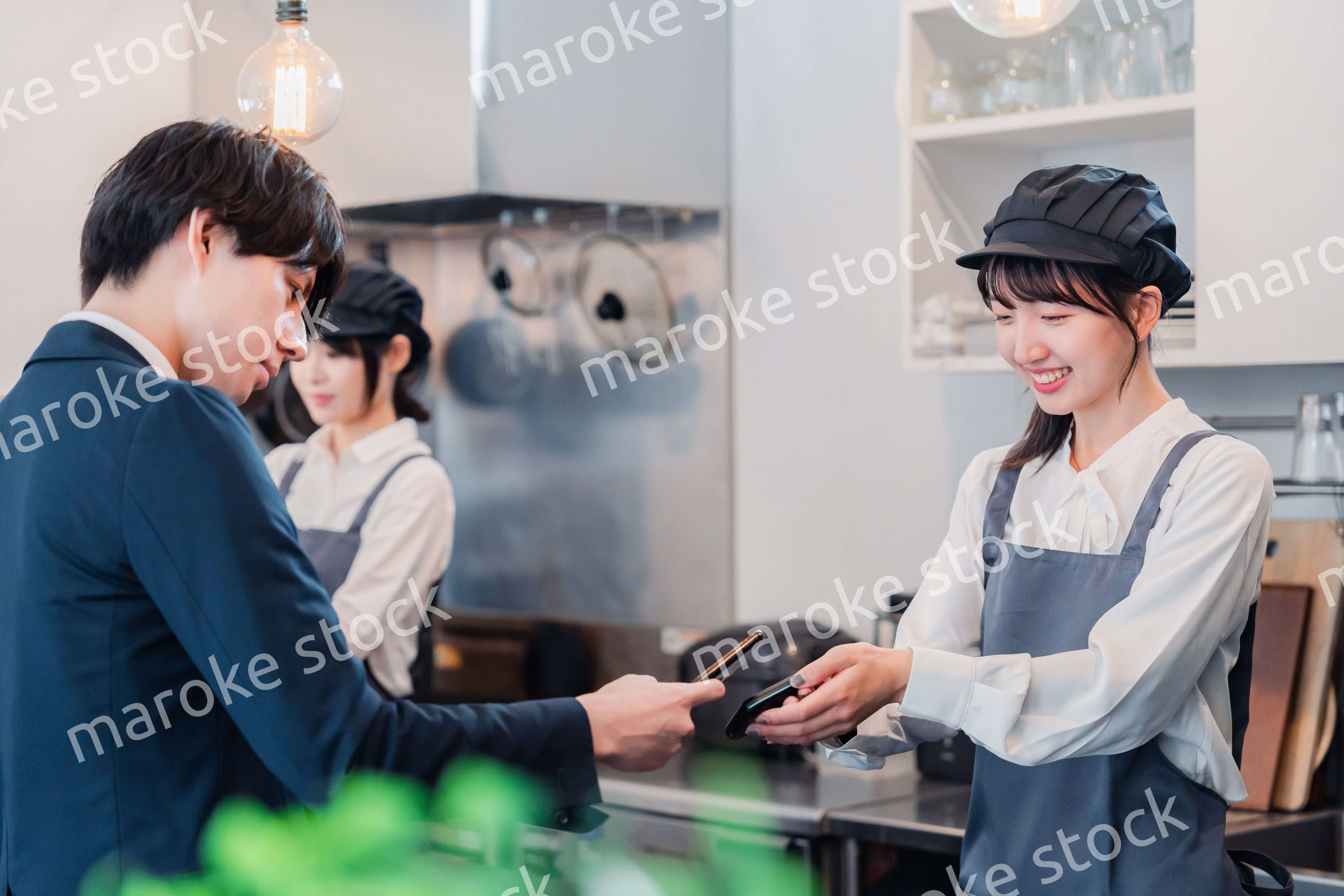 スマホでタッチ決済をする男性