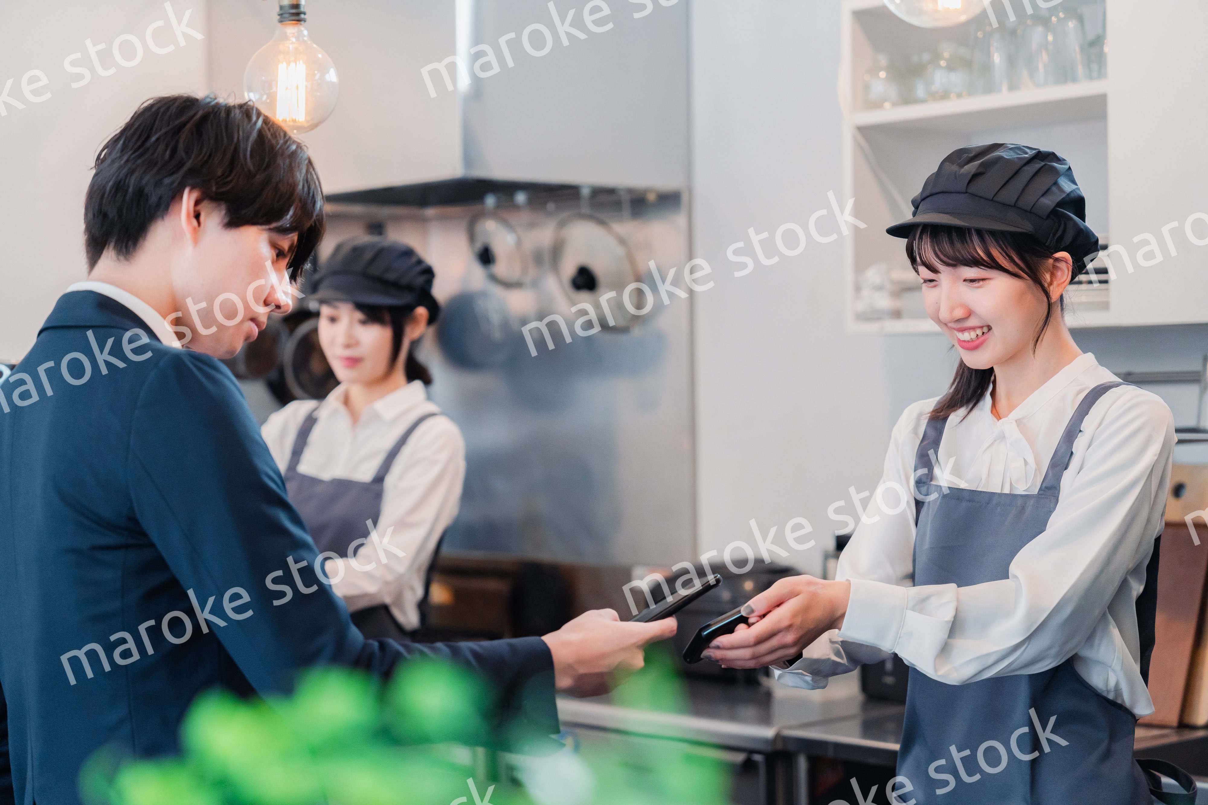 スマホでタッチ決済をする男性