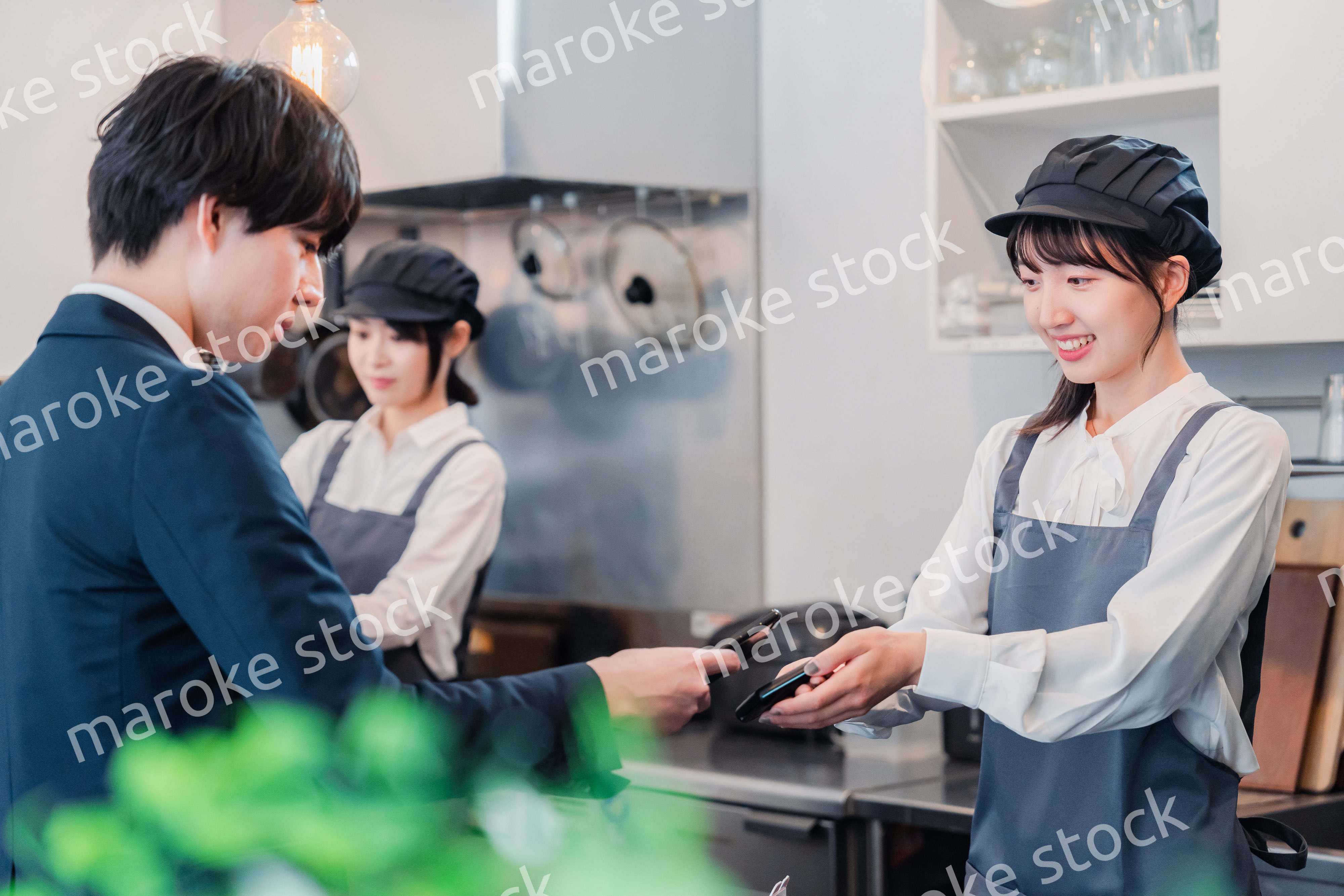 スマホでタッチ決済をする男性