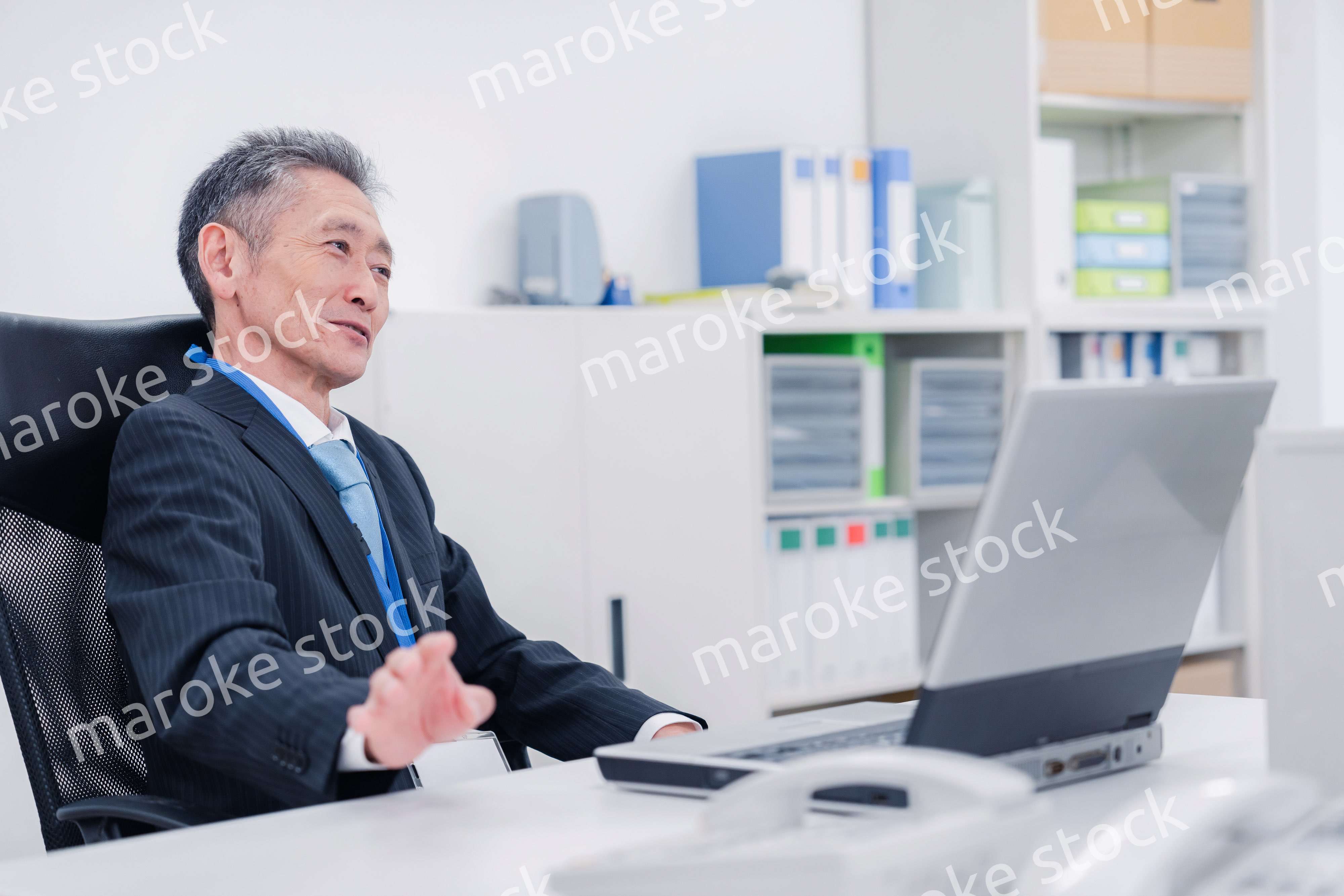 会社で自分の意見を語る管理職の男性