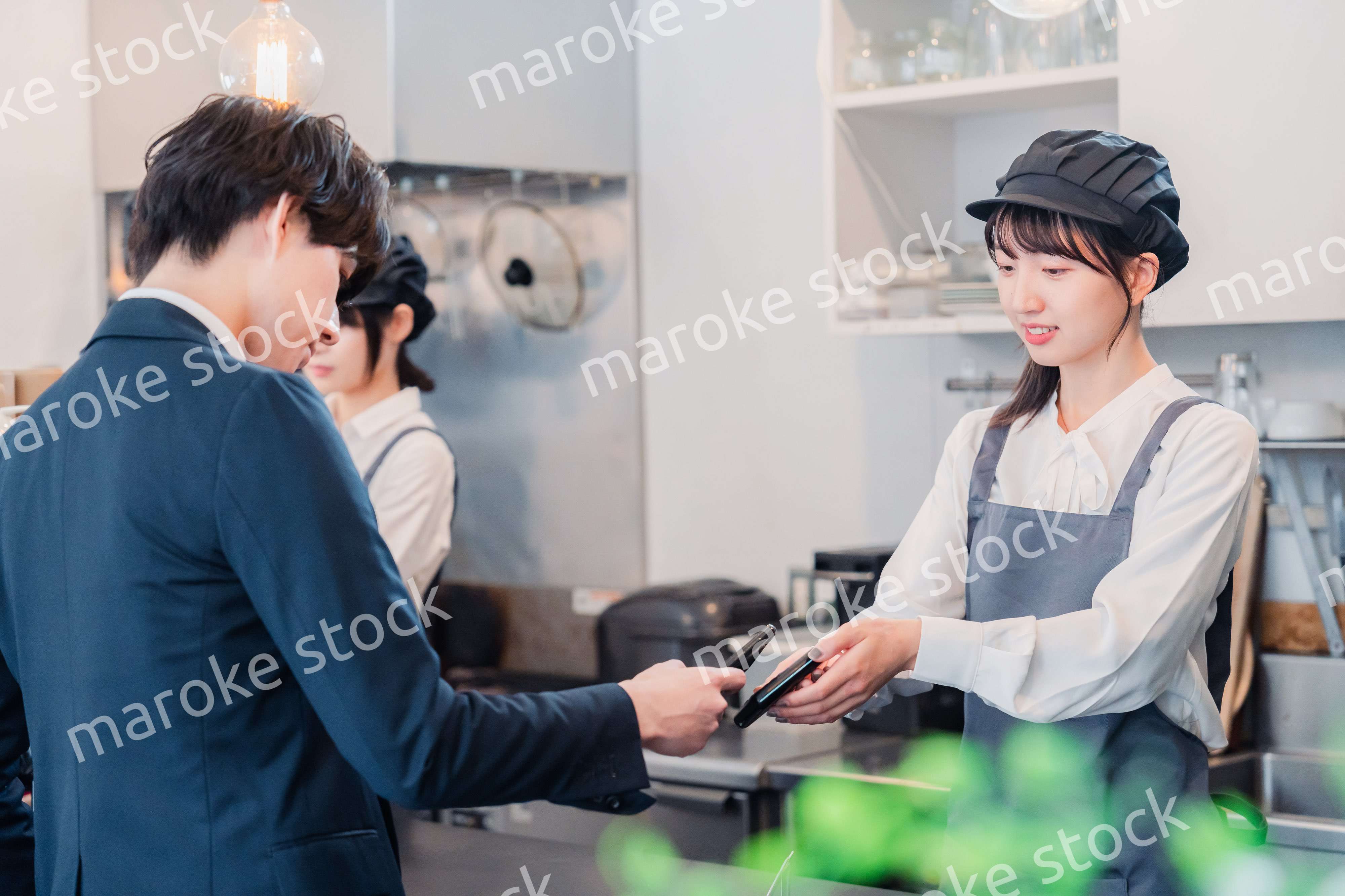 スマホでタッチ決済をする男性