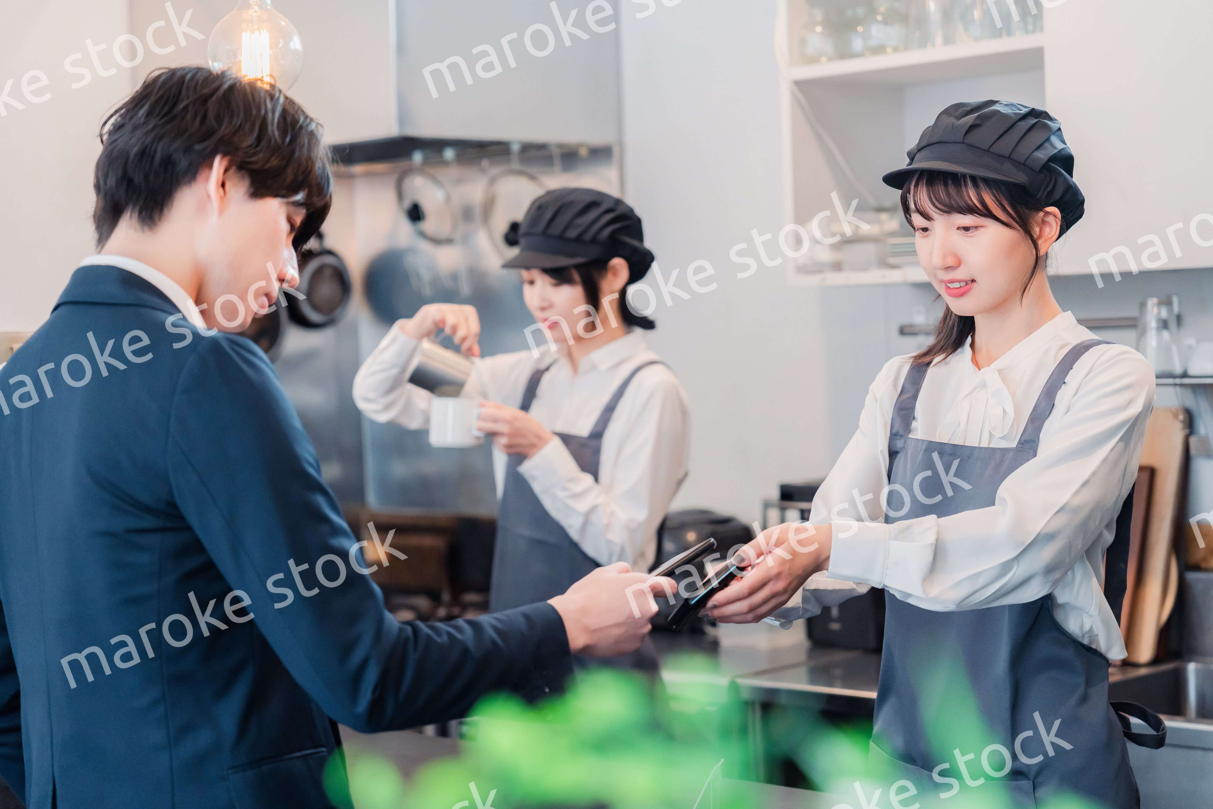 スマホでタッチ決済をする男性