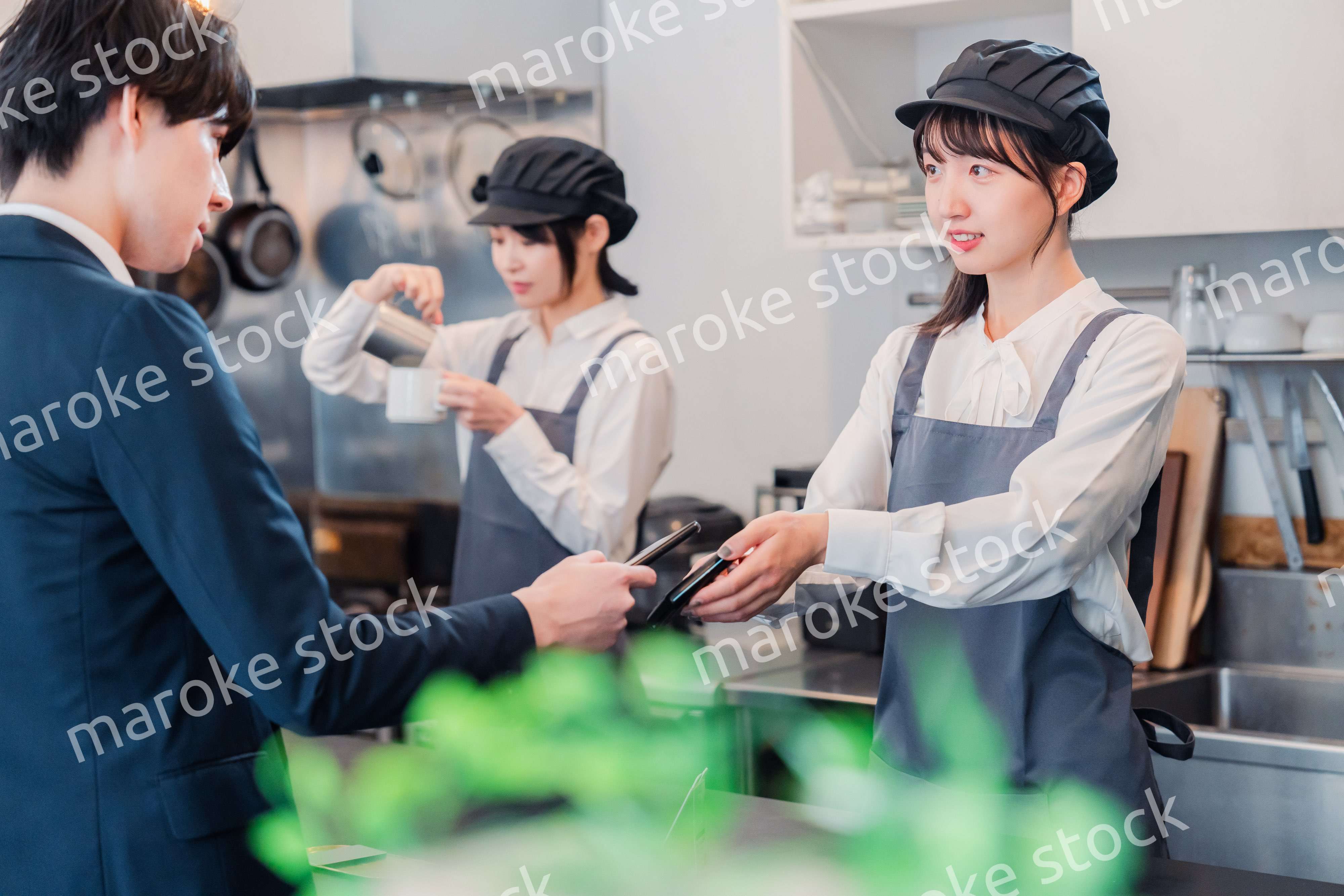 スマホでタッチ決済をする男性