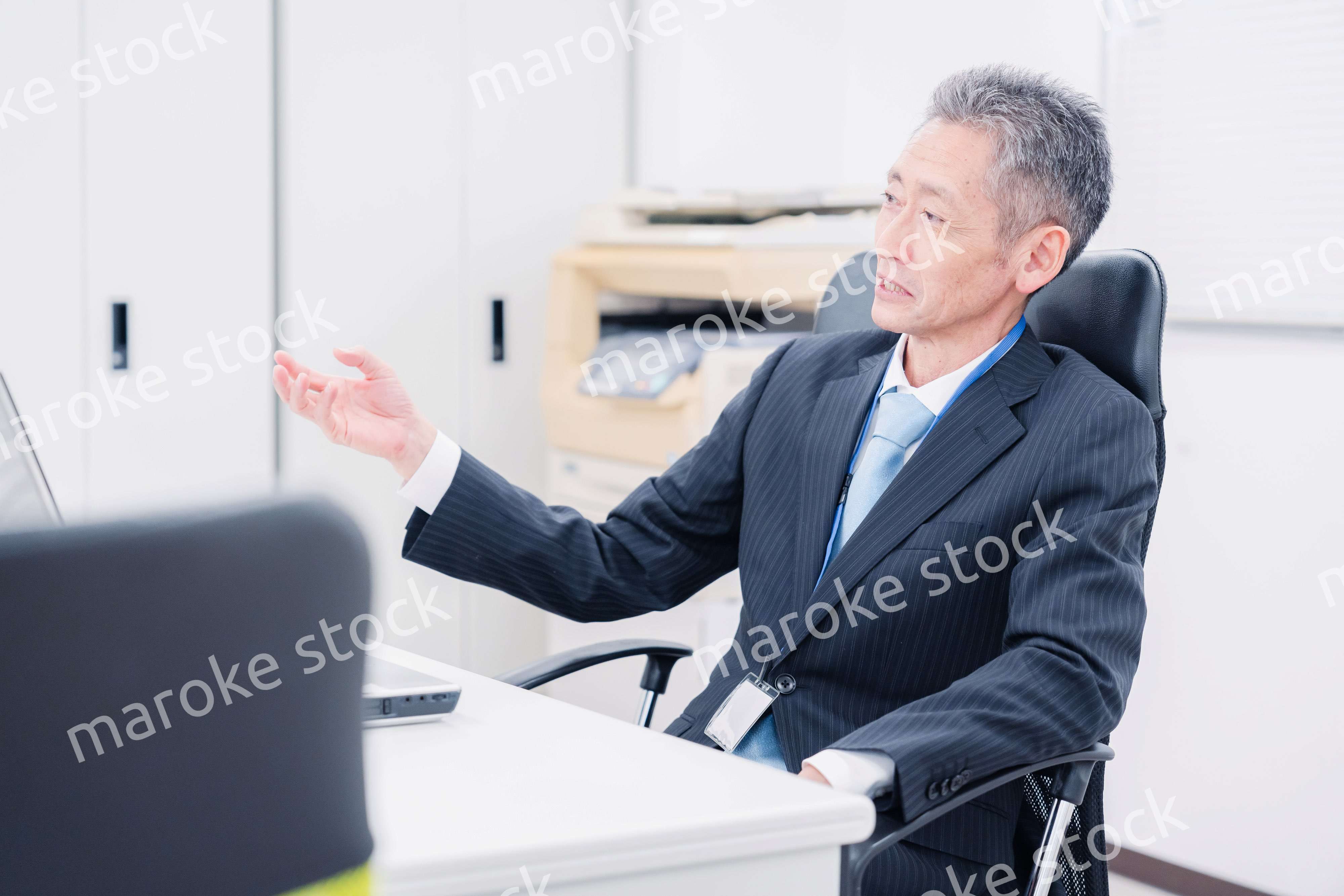 会社で自分の意見を語る管理職の男性