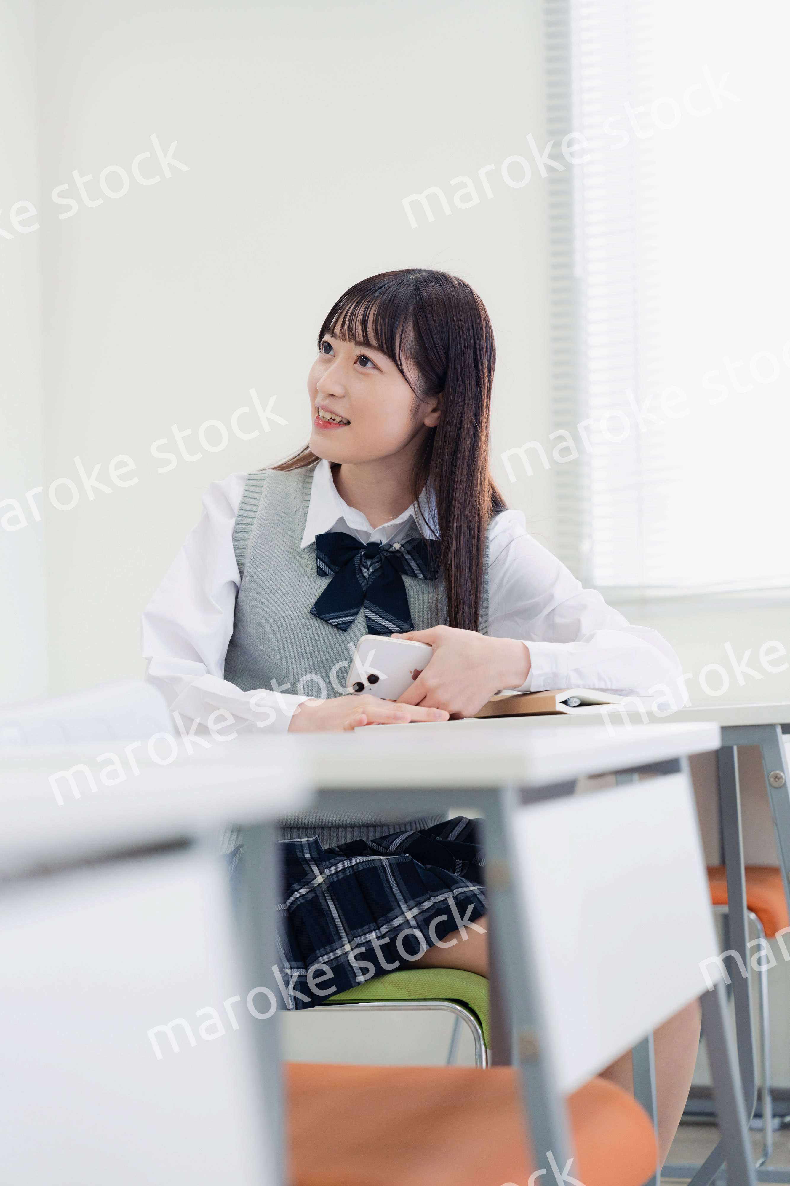 同級生と教室で仲良く話す高校生