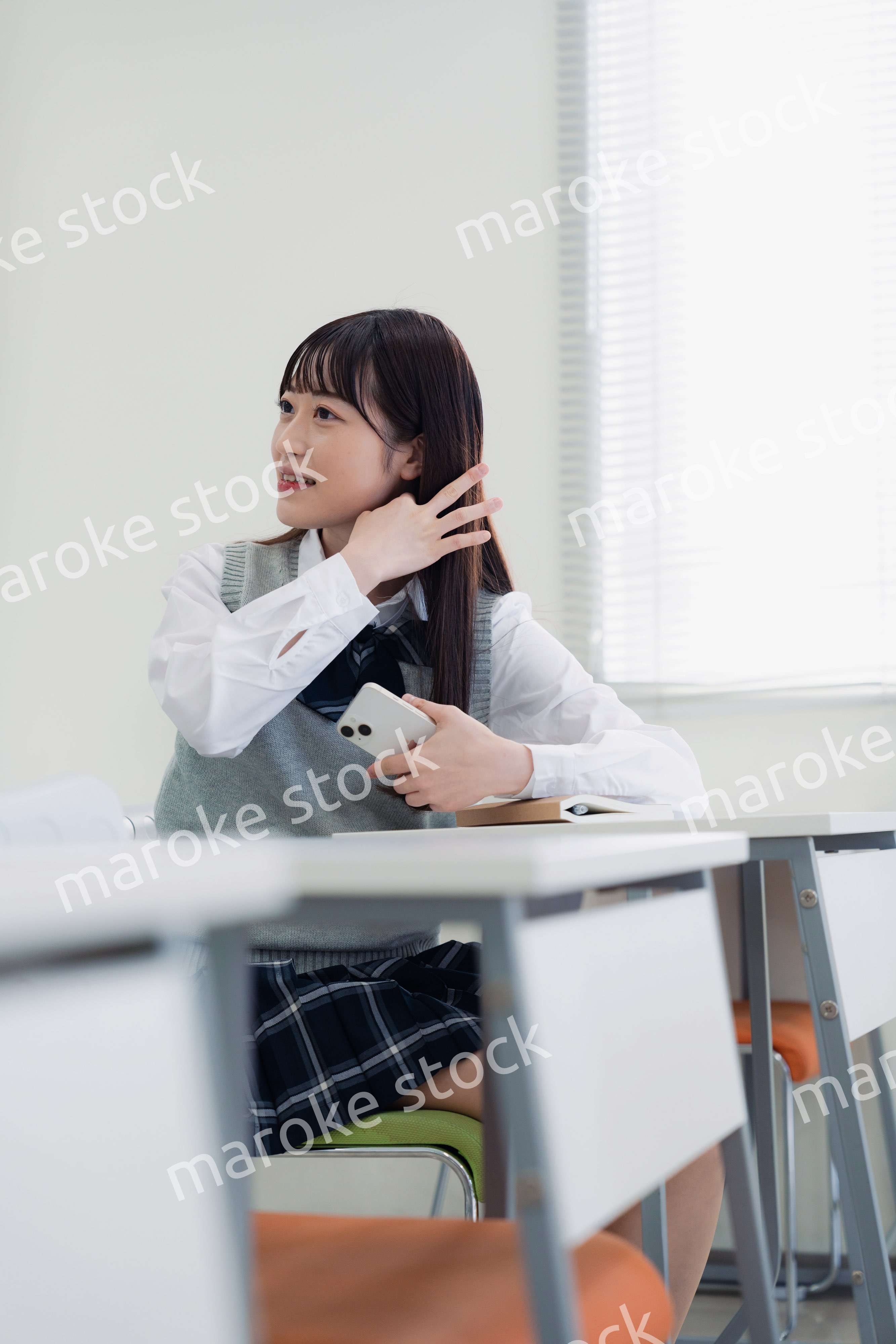 同級生と教室で仲良く話す高校生