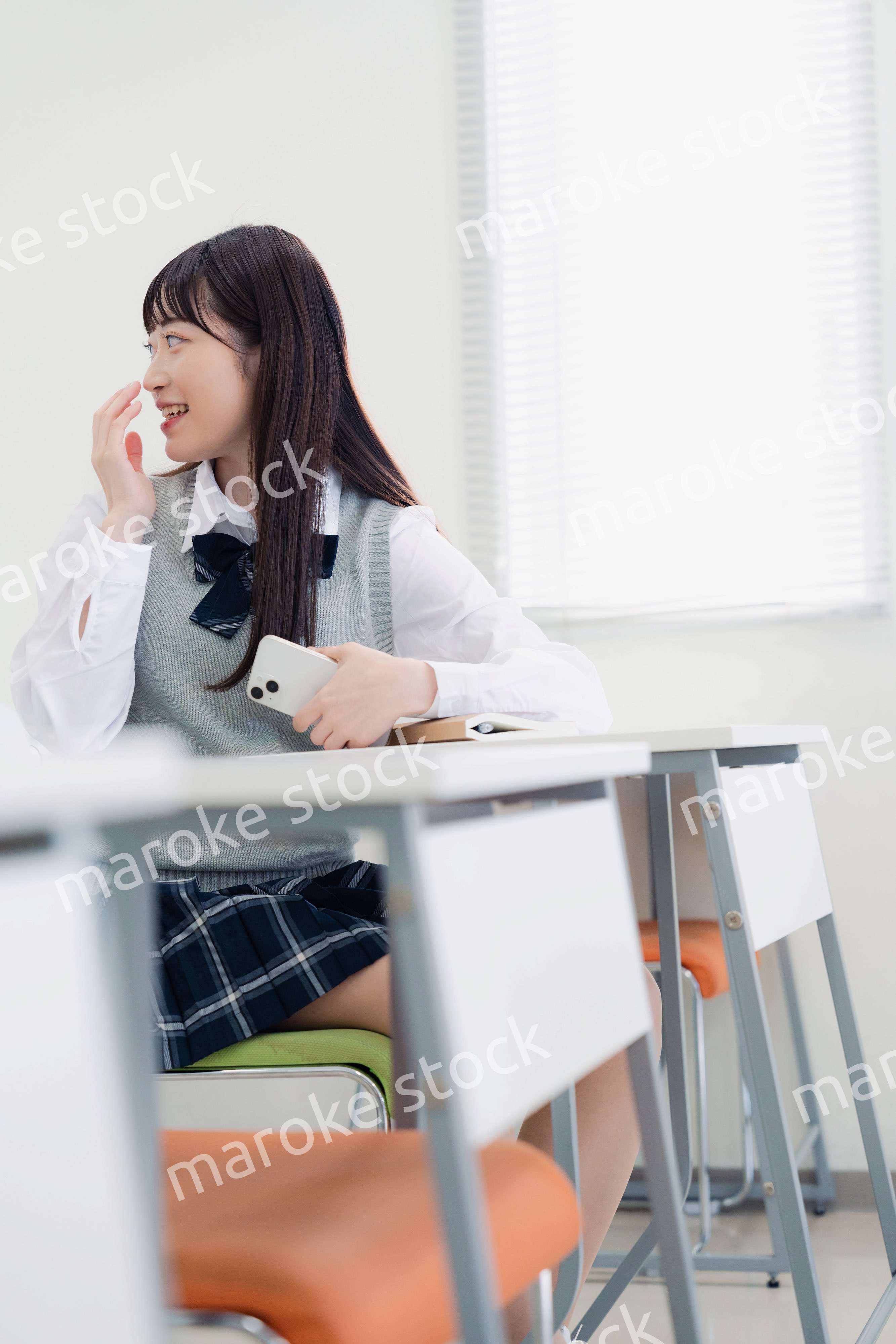 同級生と教室で仲良く話す高校生