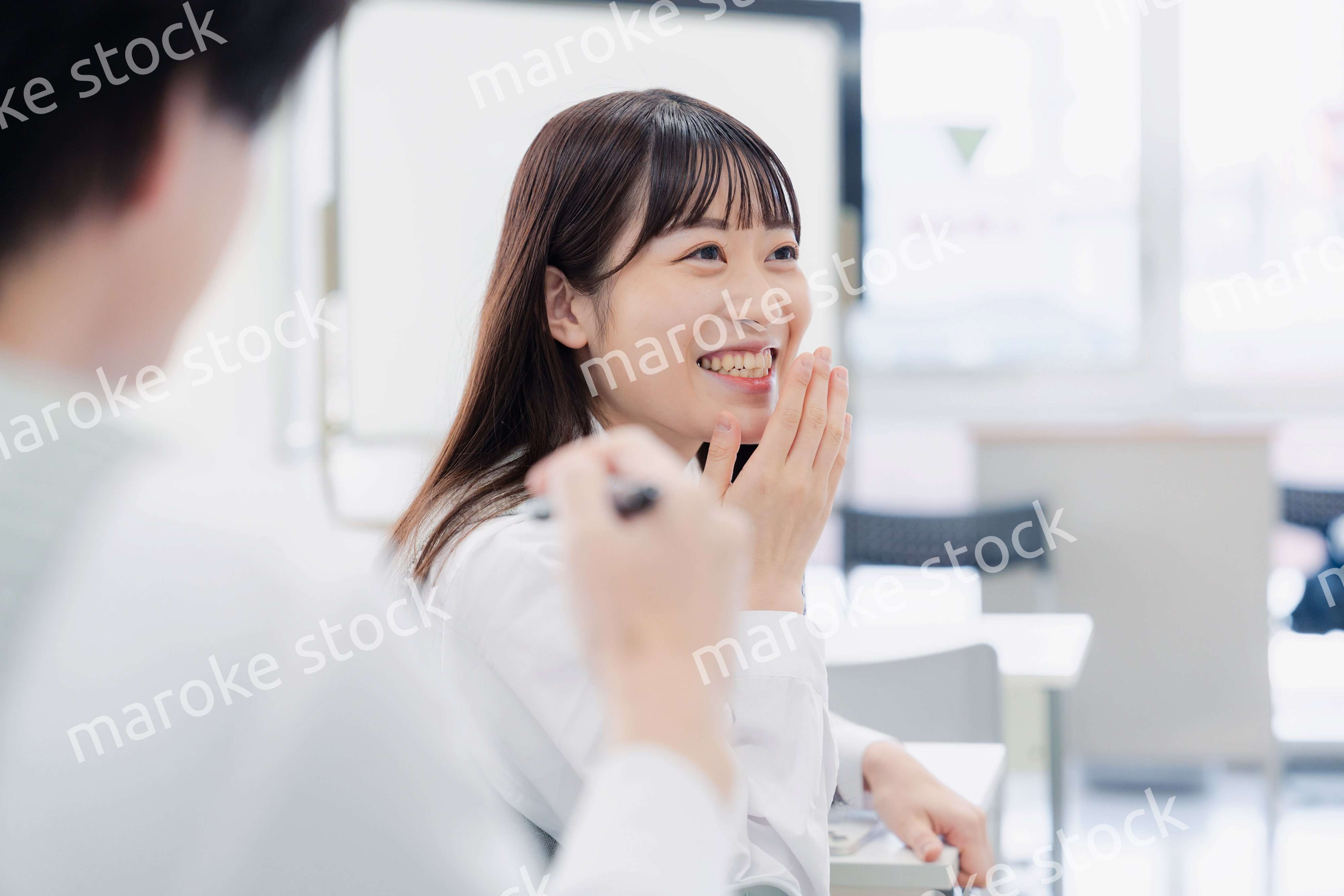 同級生と教室で仲良く話す高校生