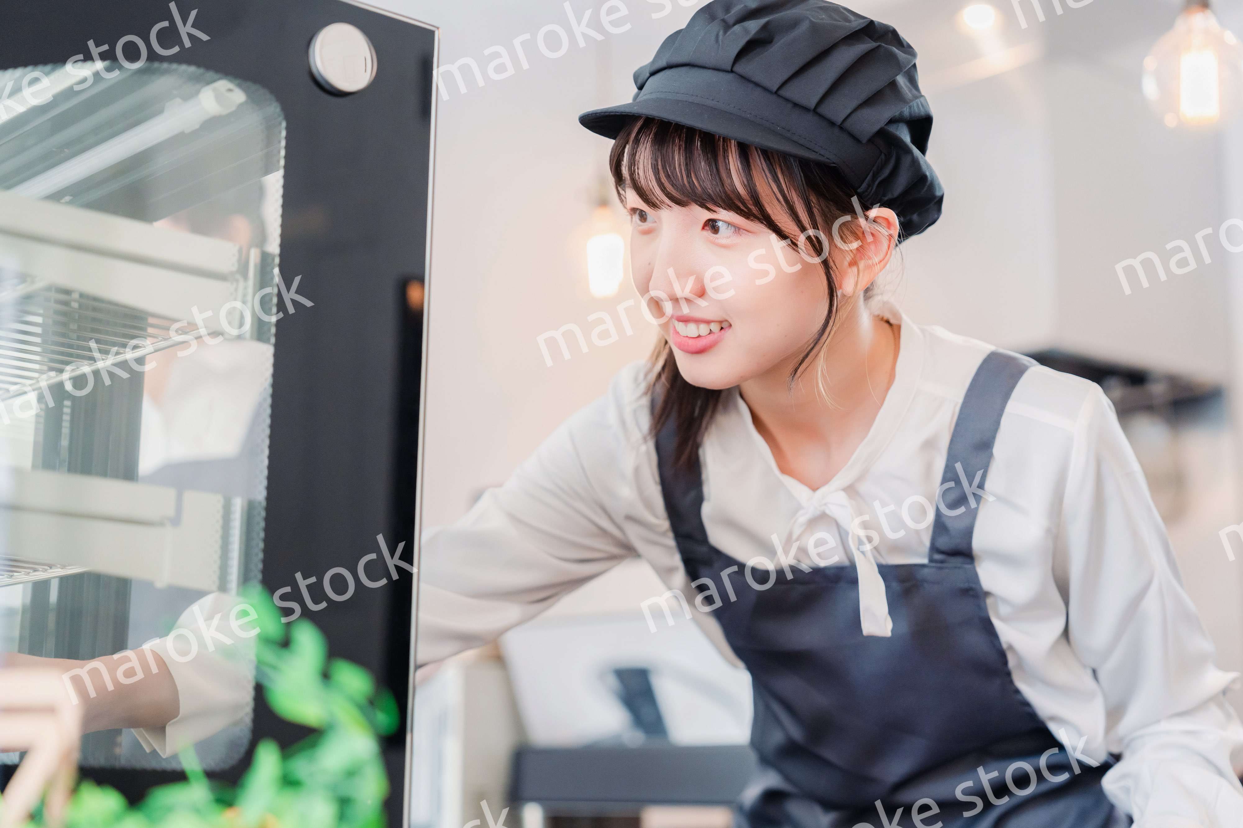 ショーケースに商品を並べる若い店員