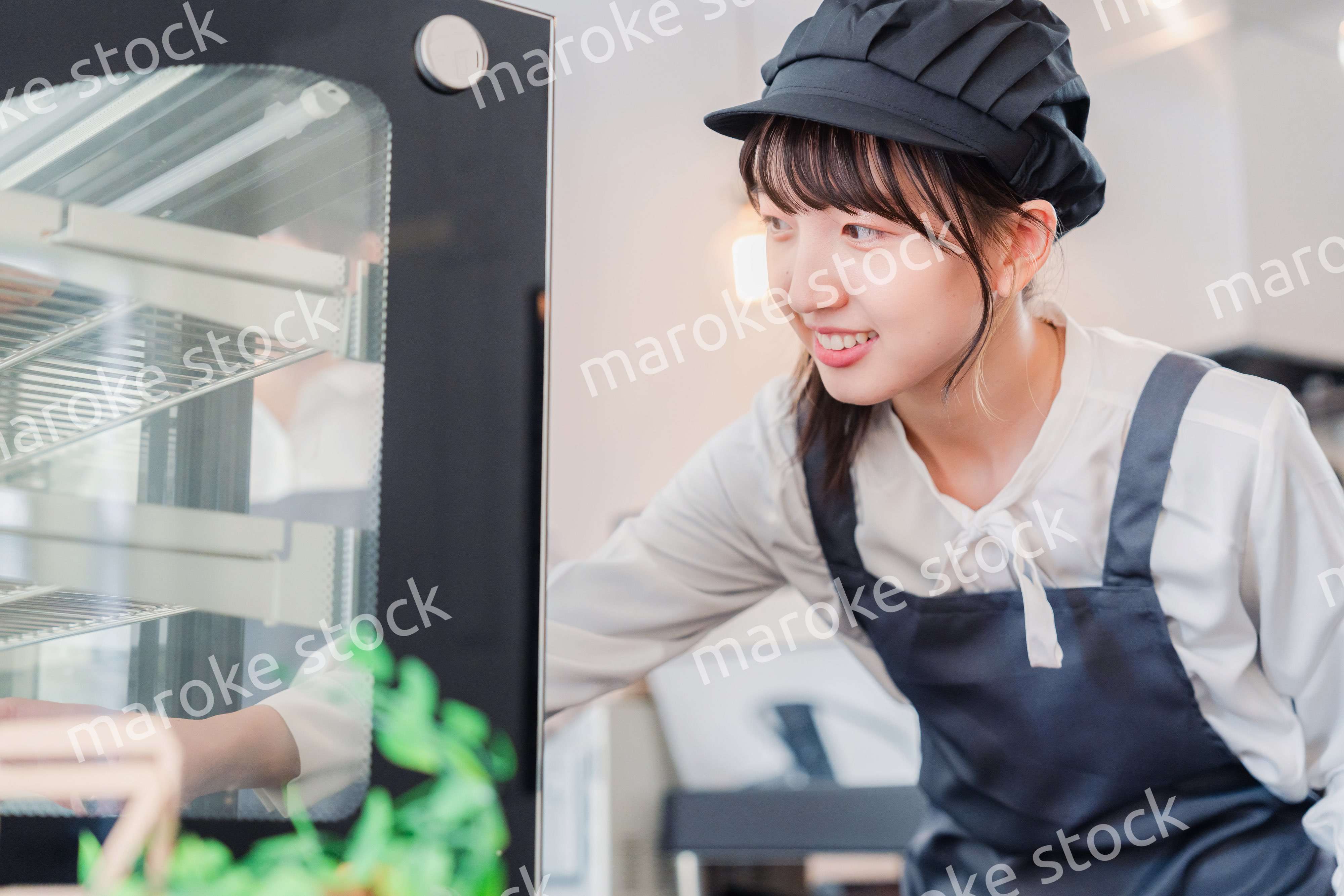 ショーケースに商品を並べる若い店員