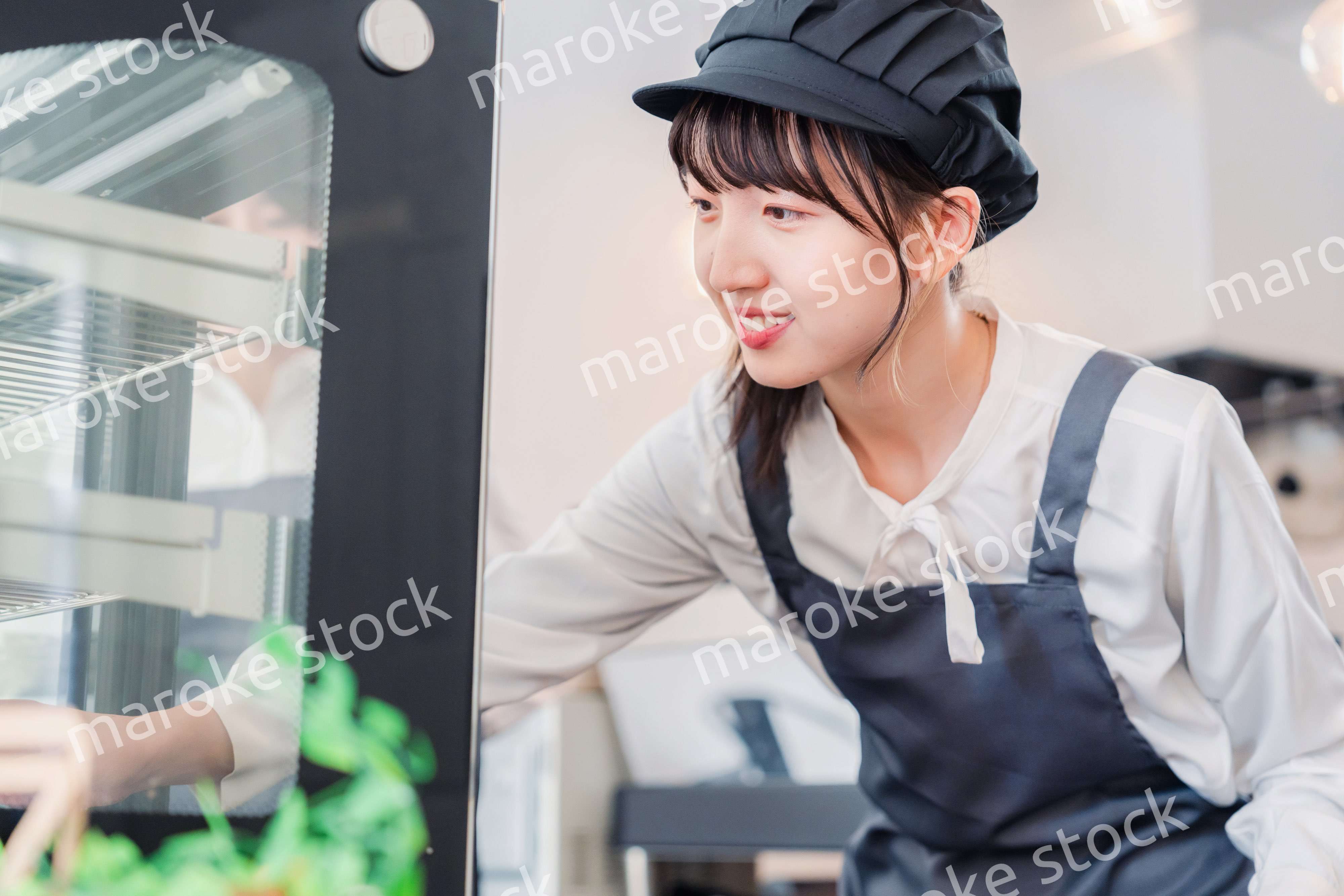 ショーケースに商品を並べる若い店員