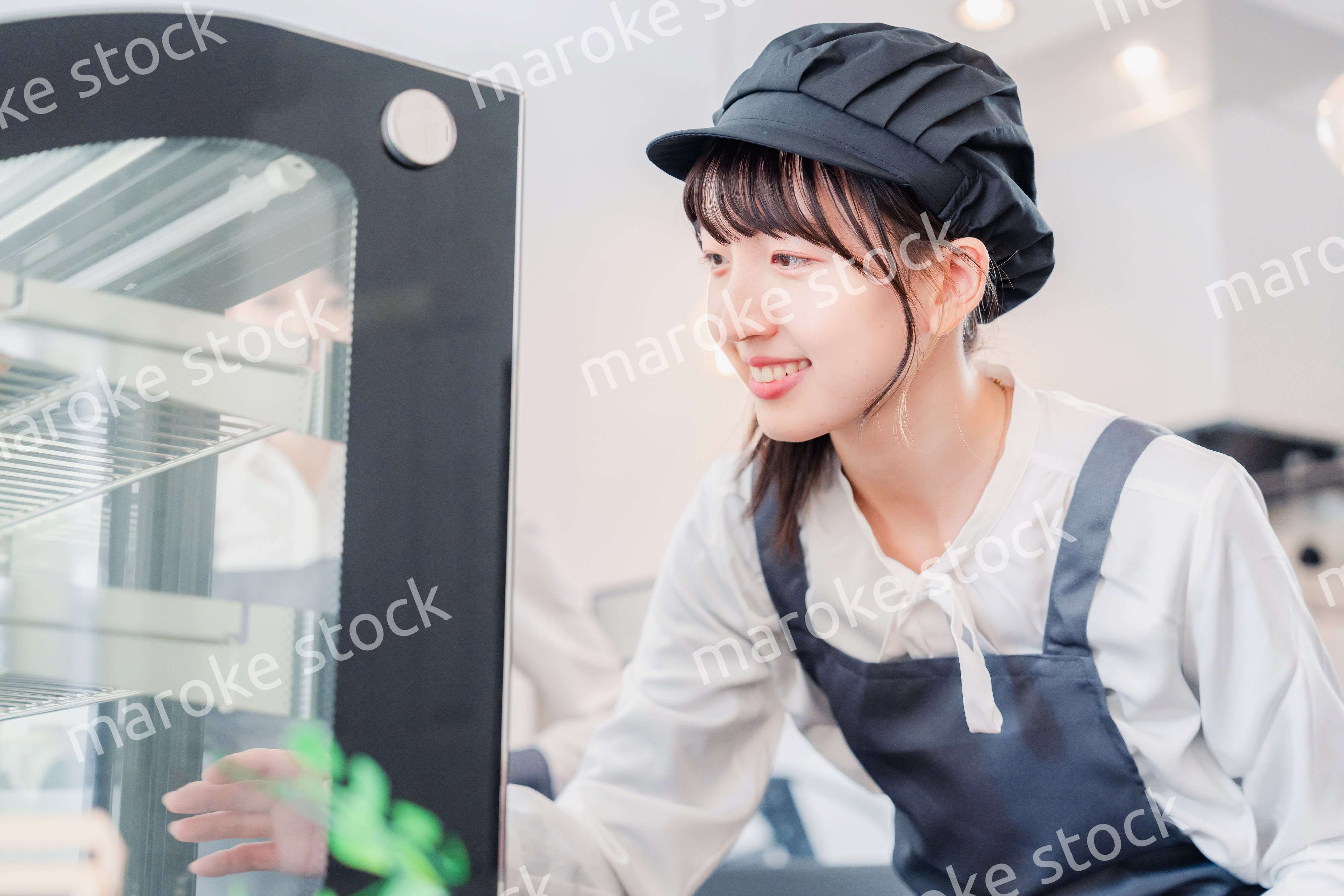 ショーケースに商品を並べる若い店員