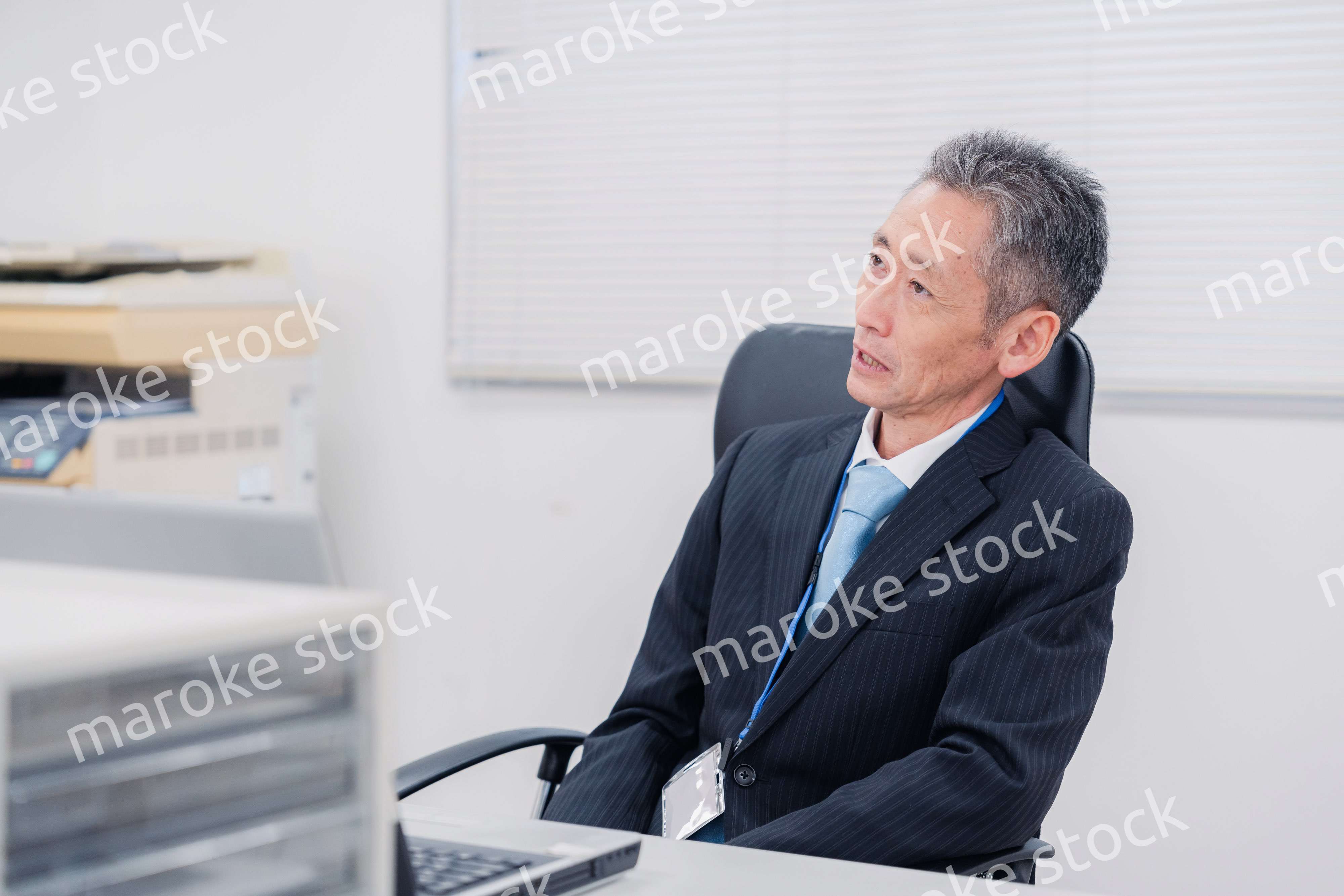 会社で自分の意見を語る管理職の男性