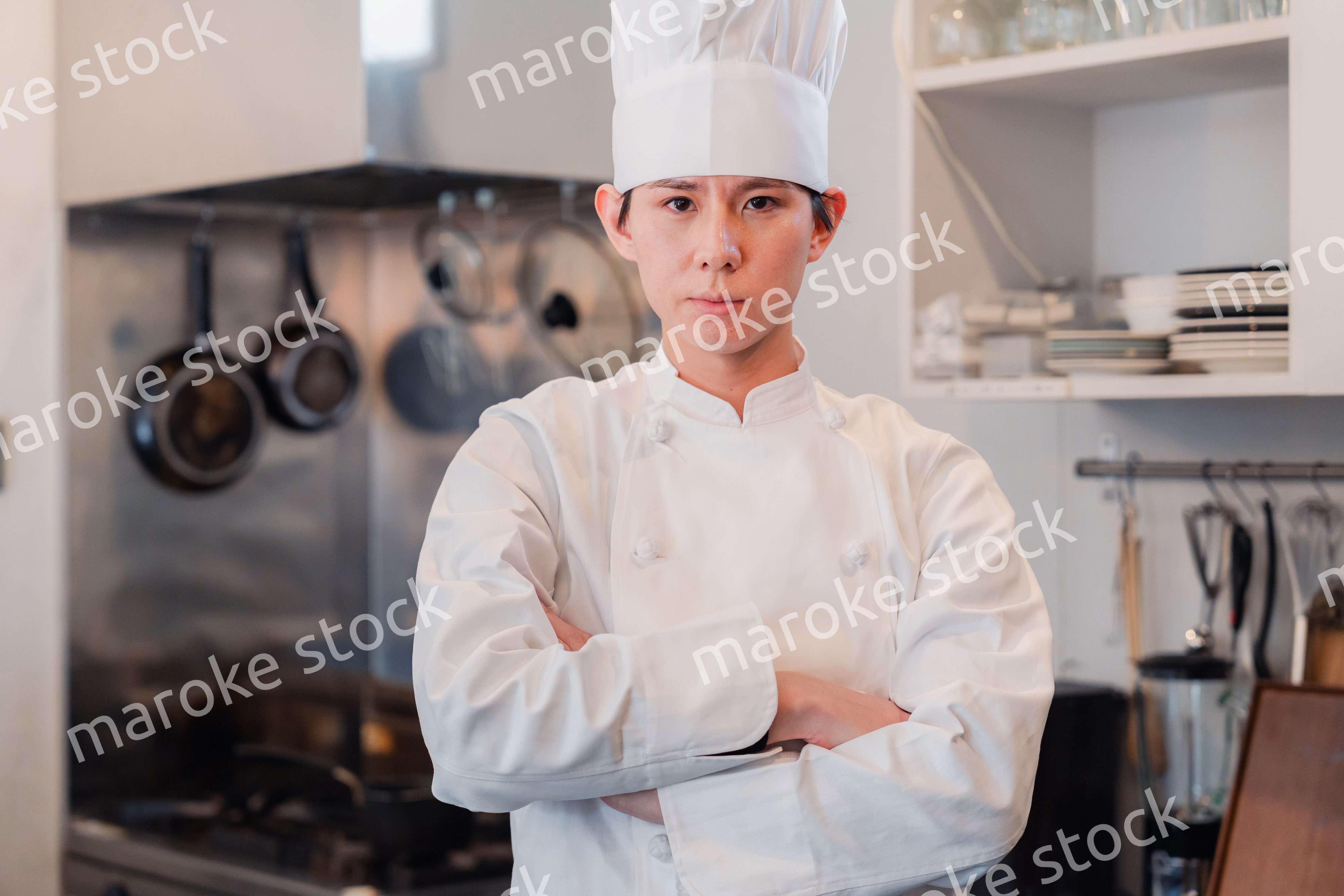 真剣な表情で腕組をする料理人