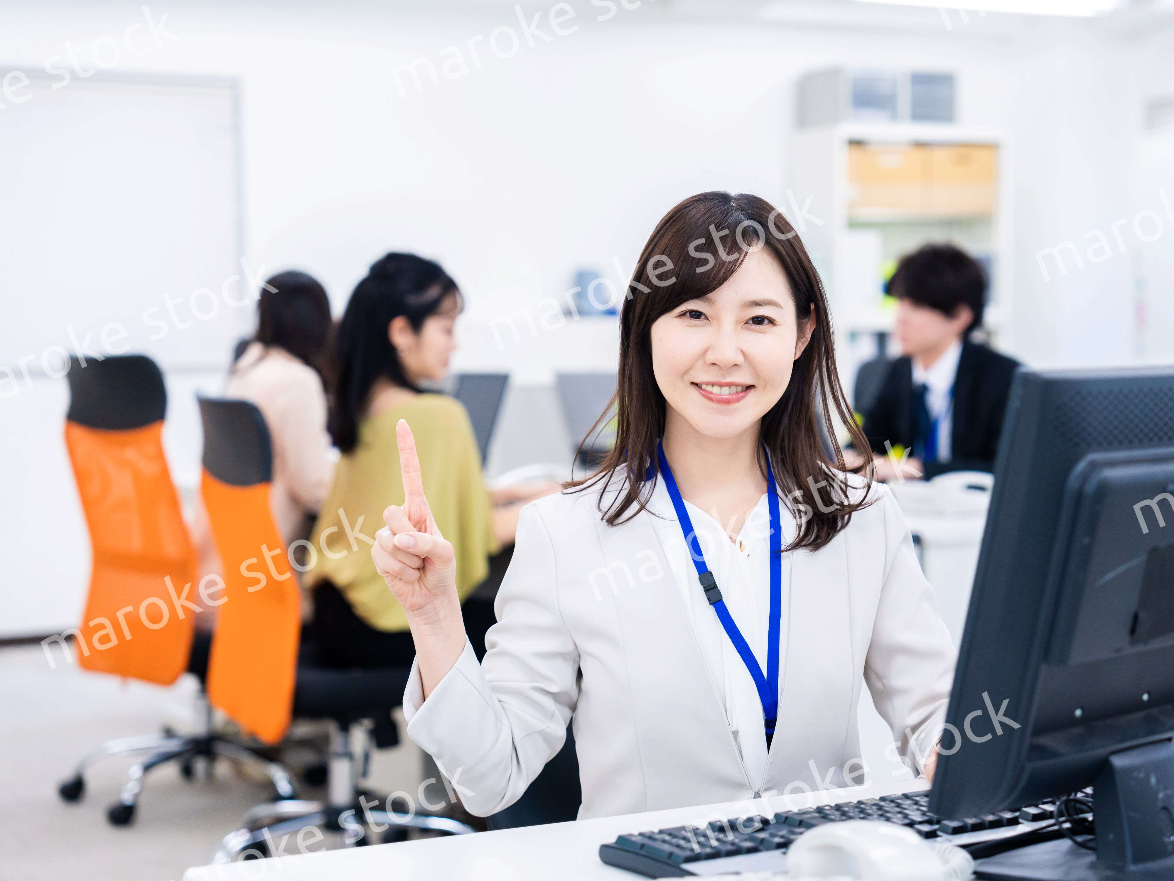 笑顔でポイントを指すビジネスウーマン