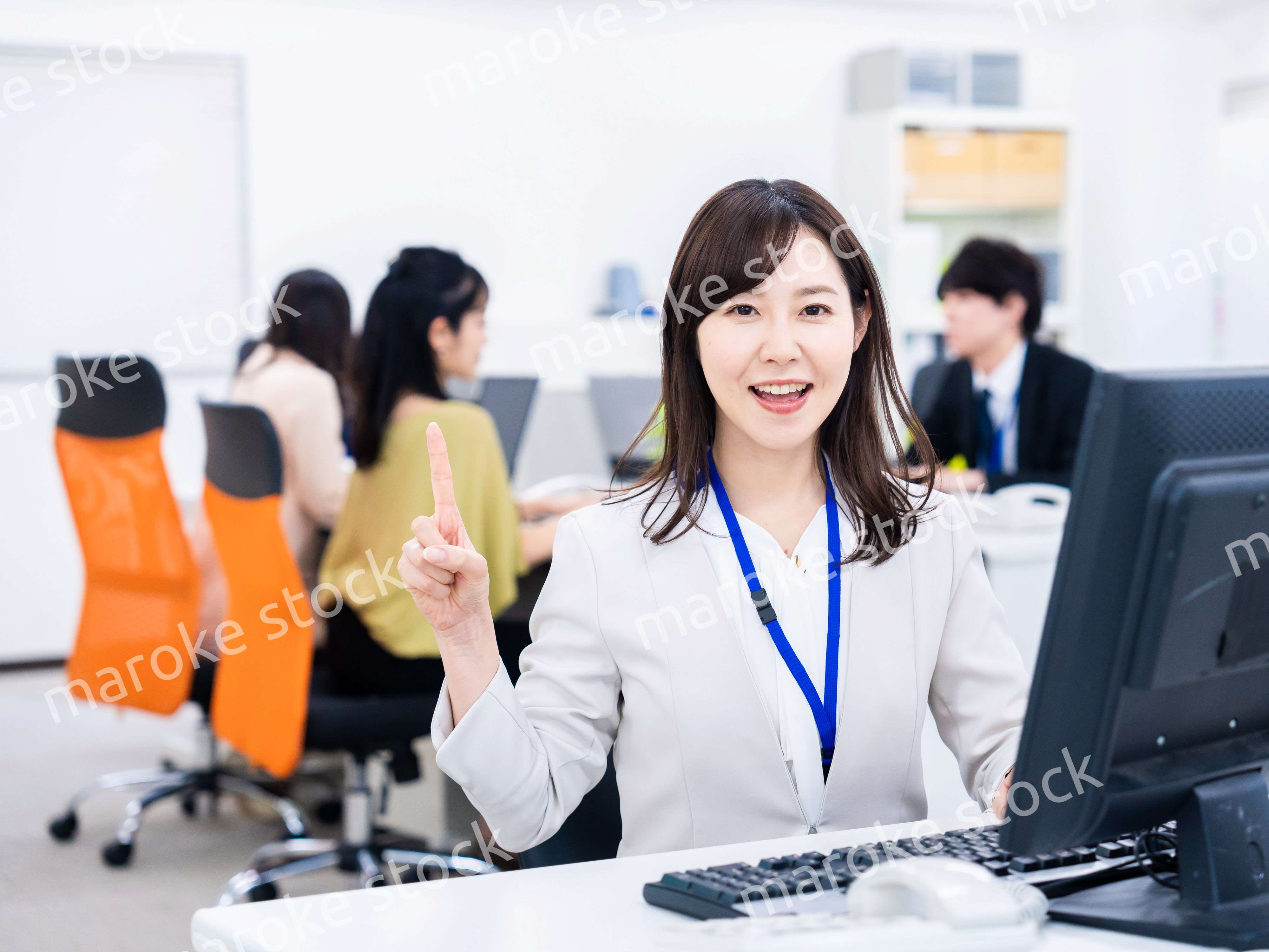 笑顔でポイントを指すビジネスウーマン